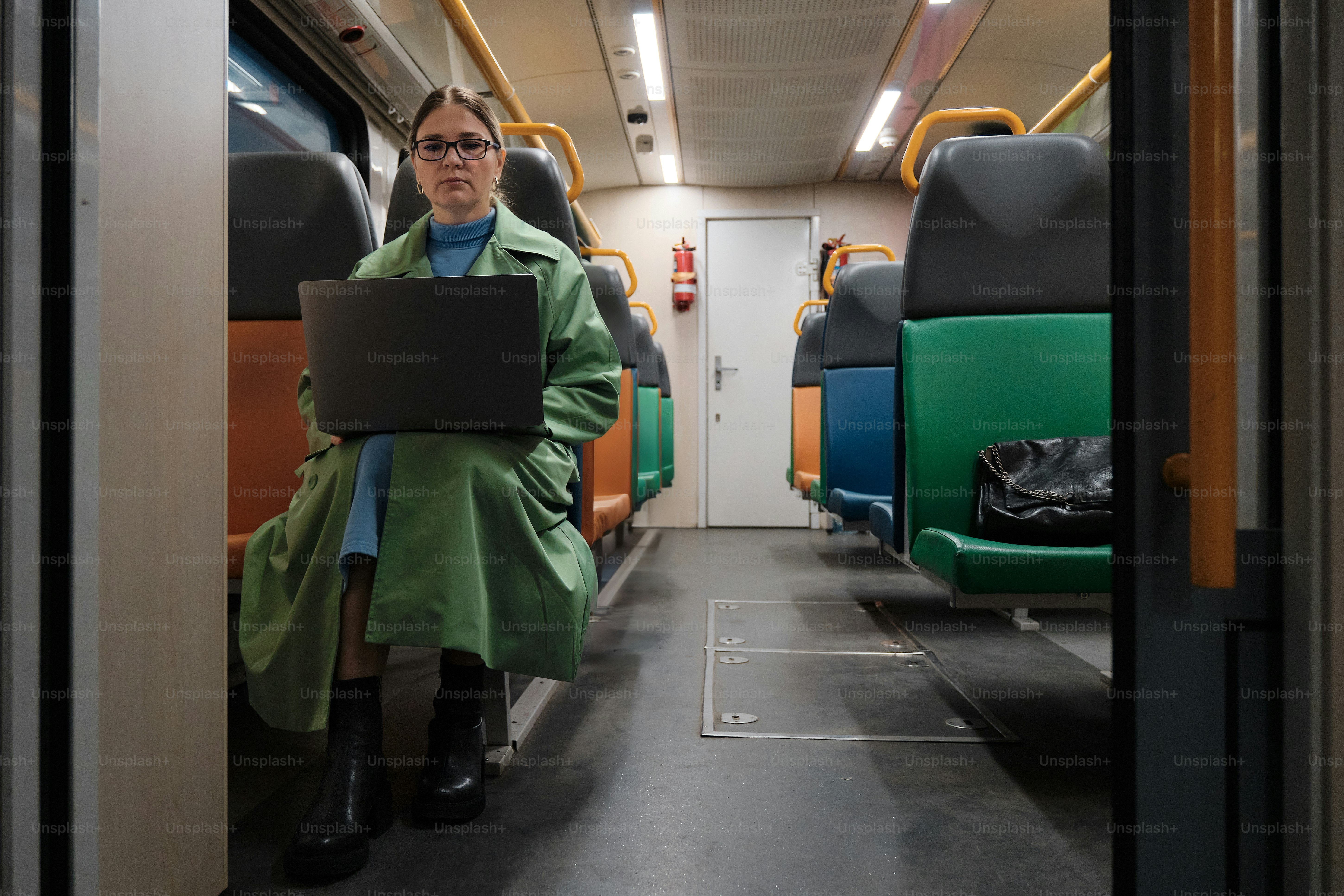 A business traveler works on a laptop on the train