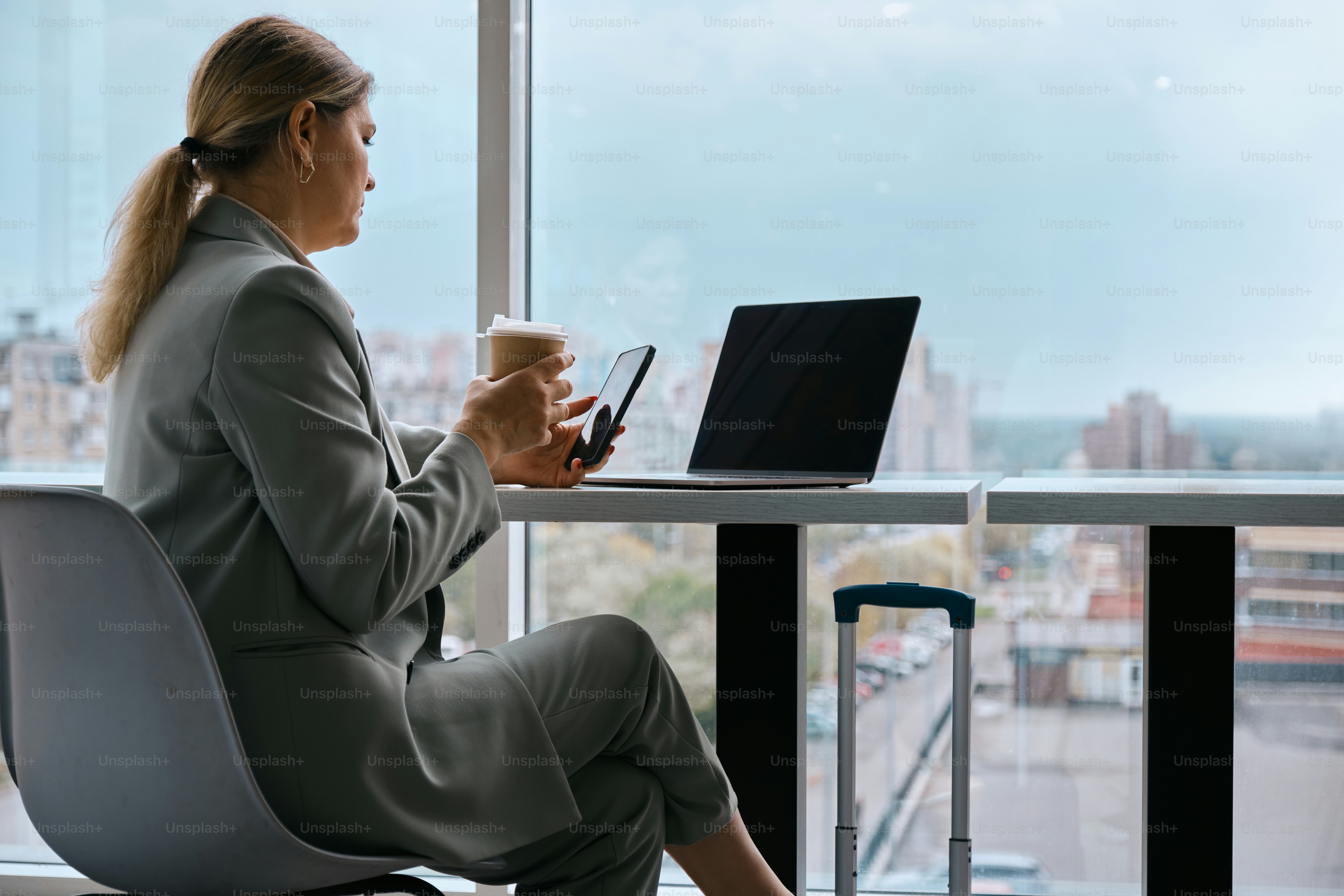 A woman sitting at a table with a laptop and a cup of coffee