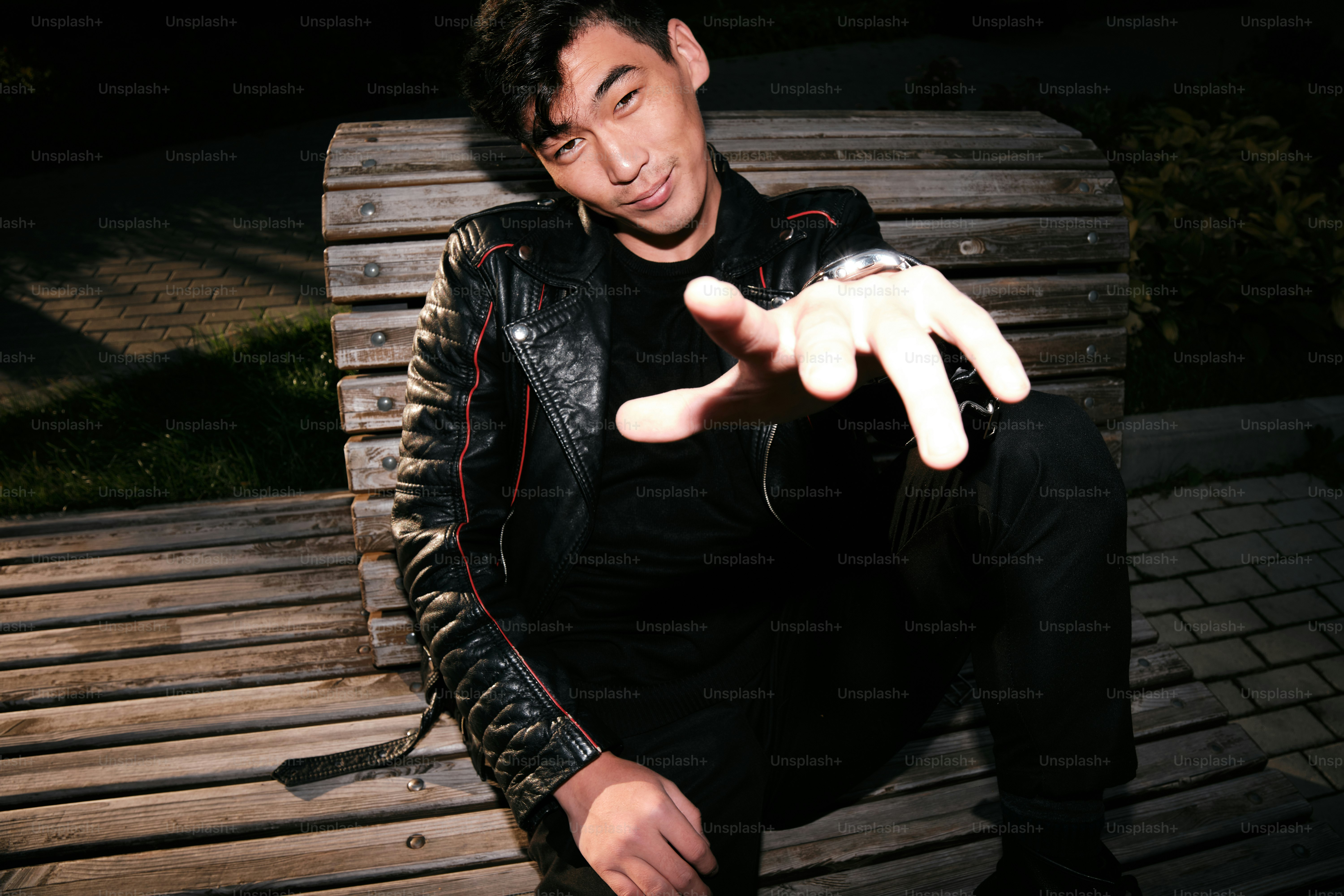 A man sitting on top of a wooden bench