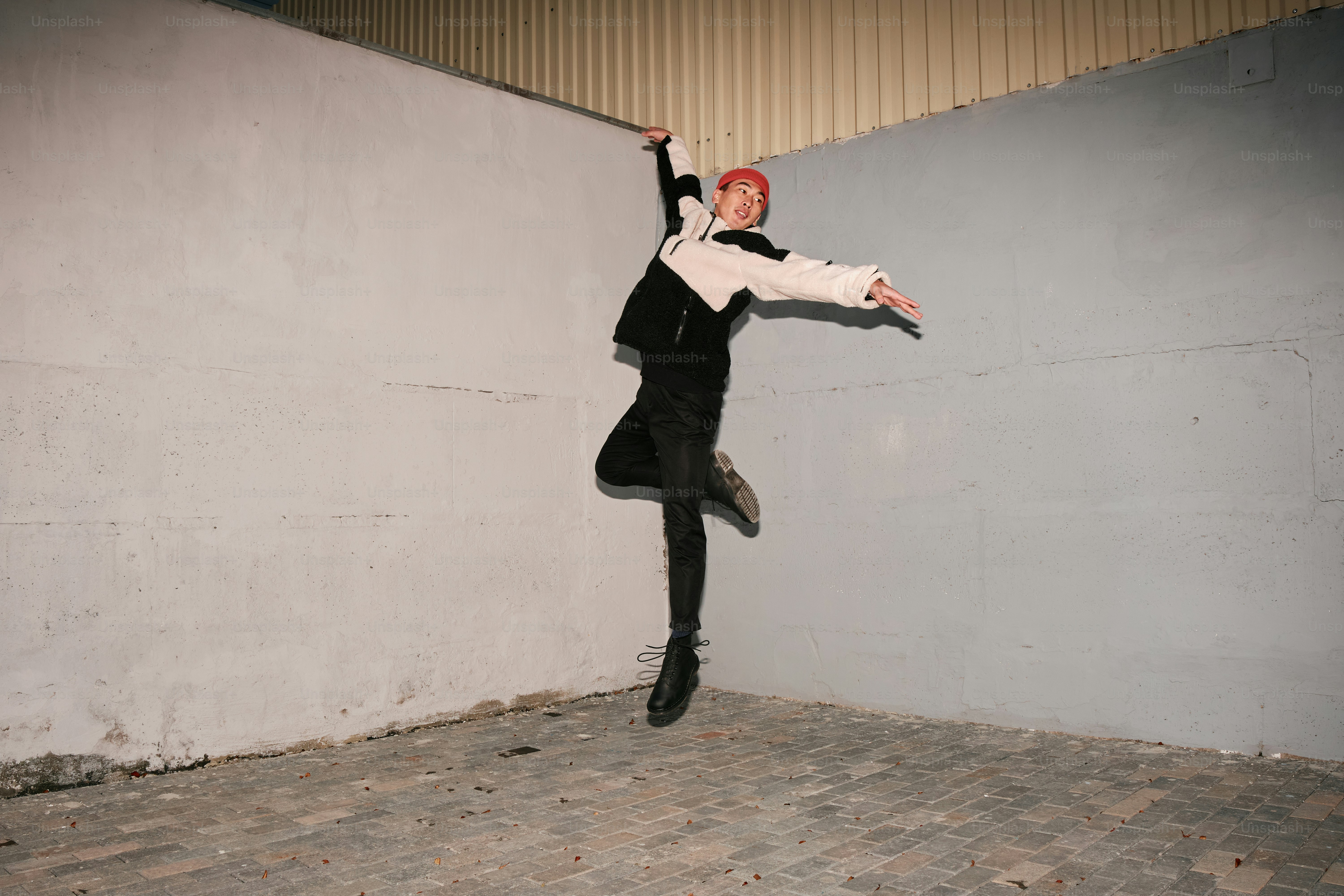 A person jumping in the air near a wall