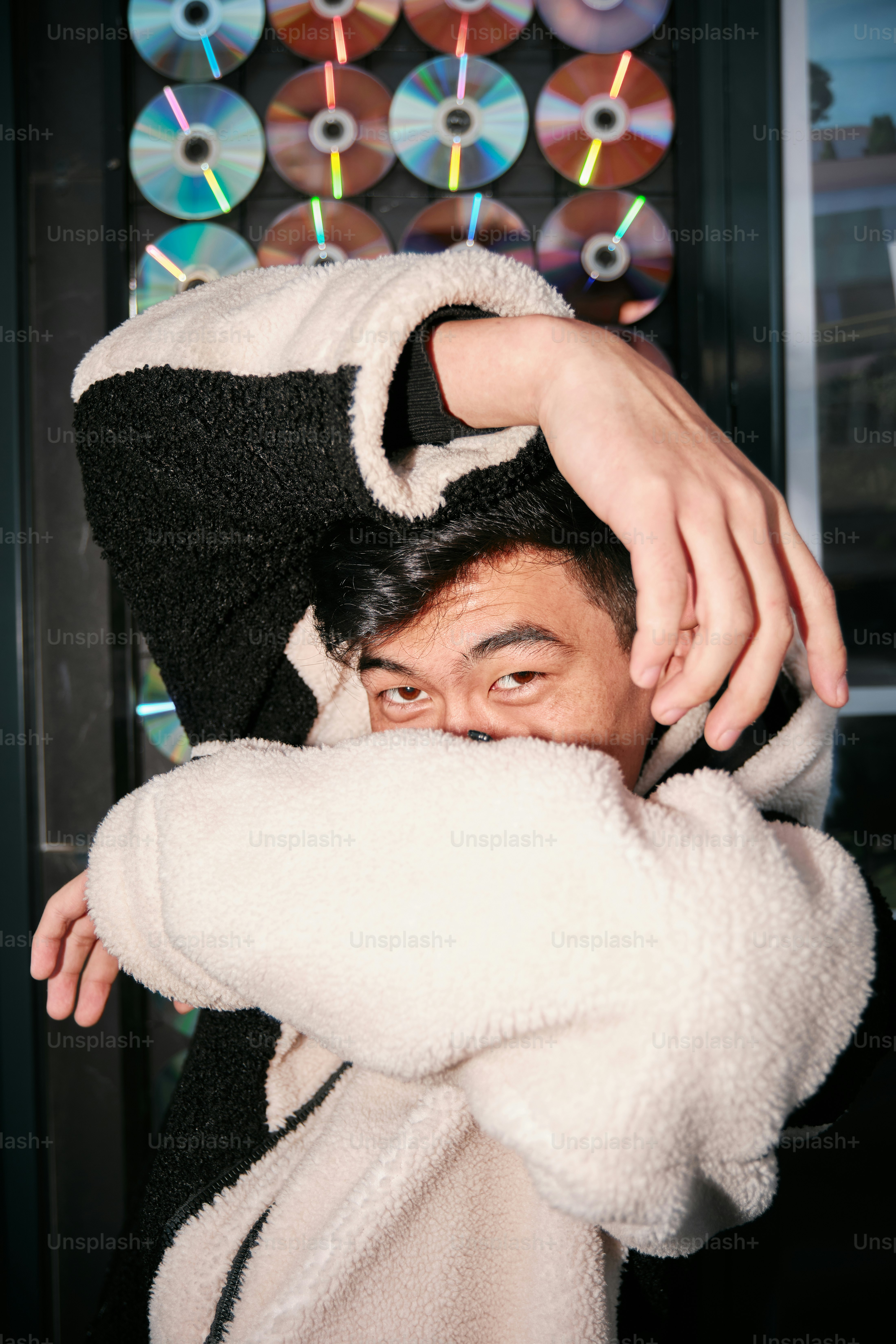 A man in a black and white jacket is covering his face photo – Portrait ...