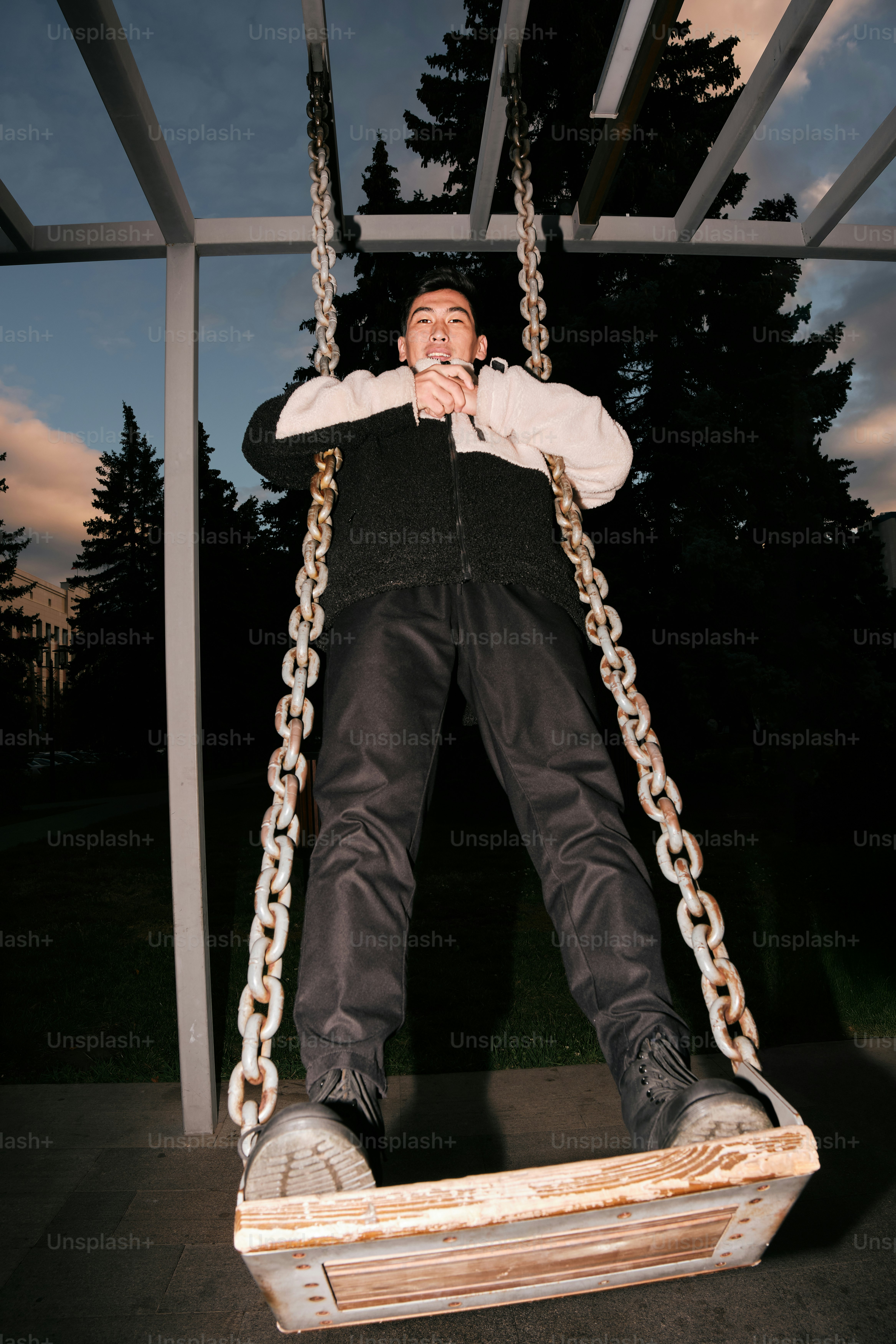 Un hombre sentado en un columpio en un parque