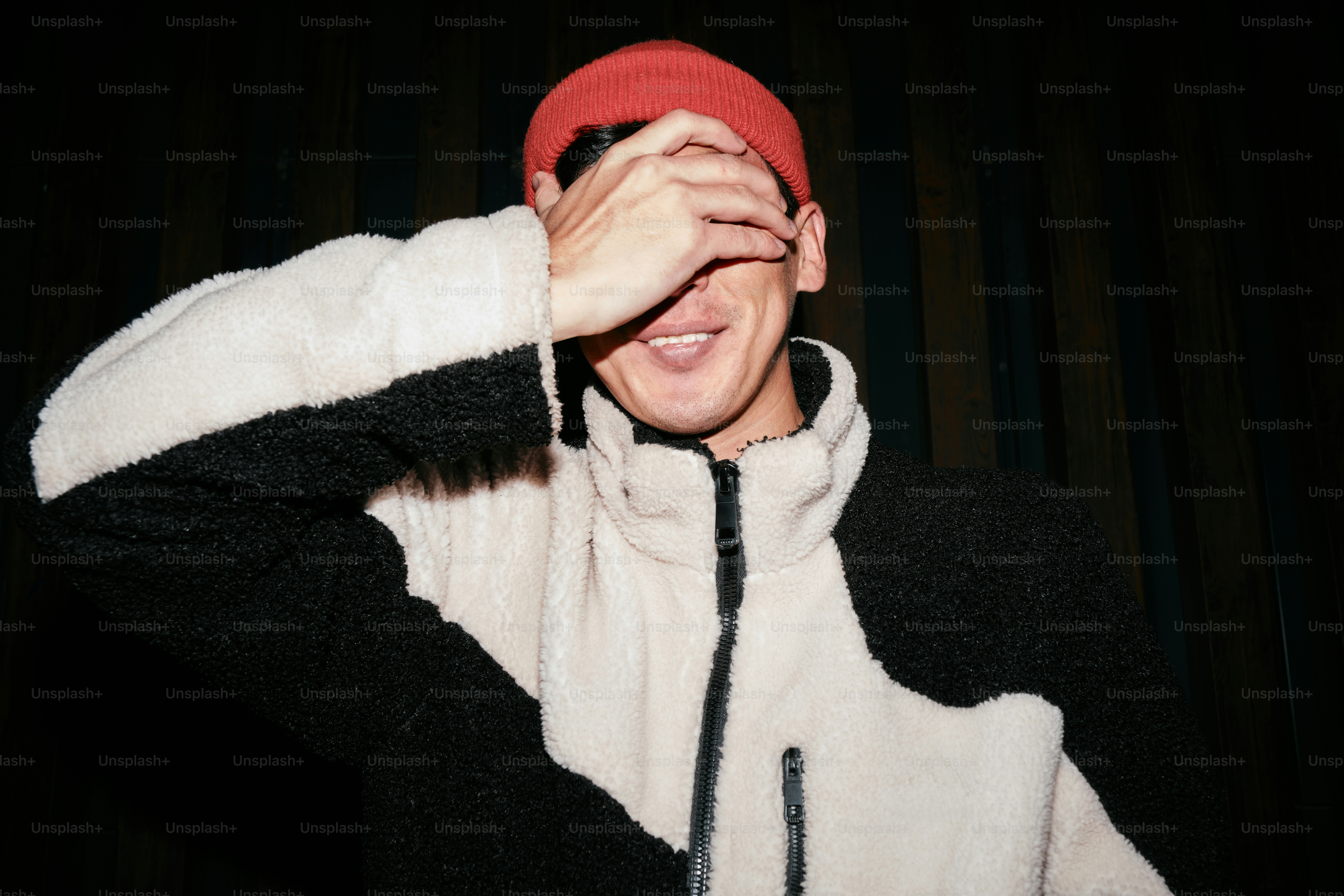 A man wearing a red hat and a black and white jacket