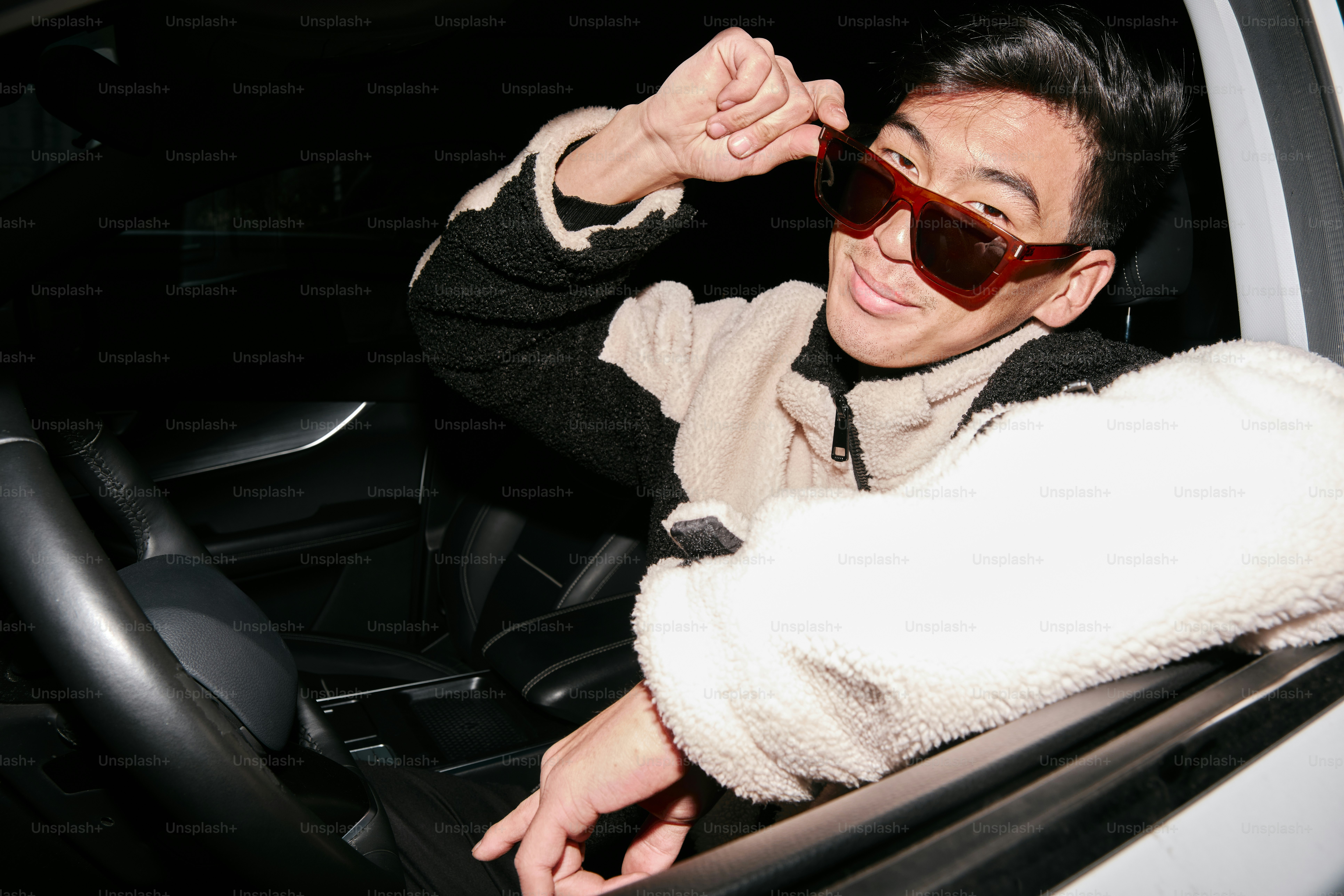 A man sitting in a car wearing sunglasses