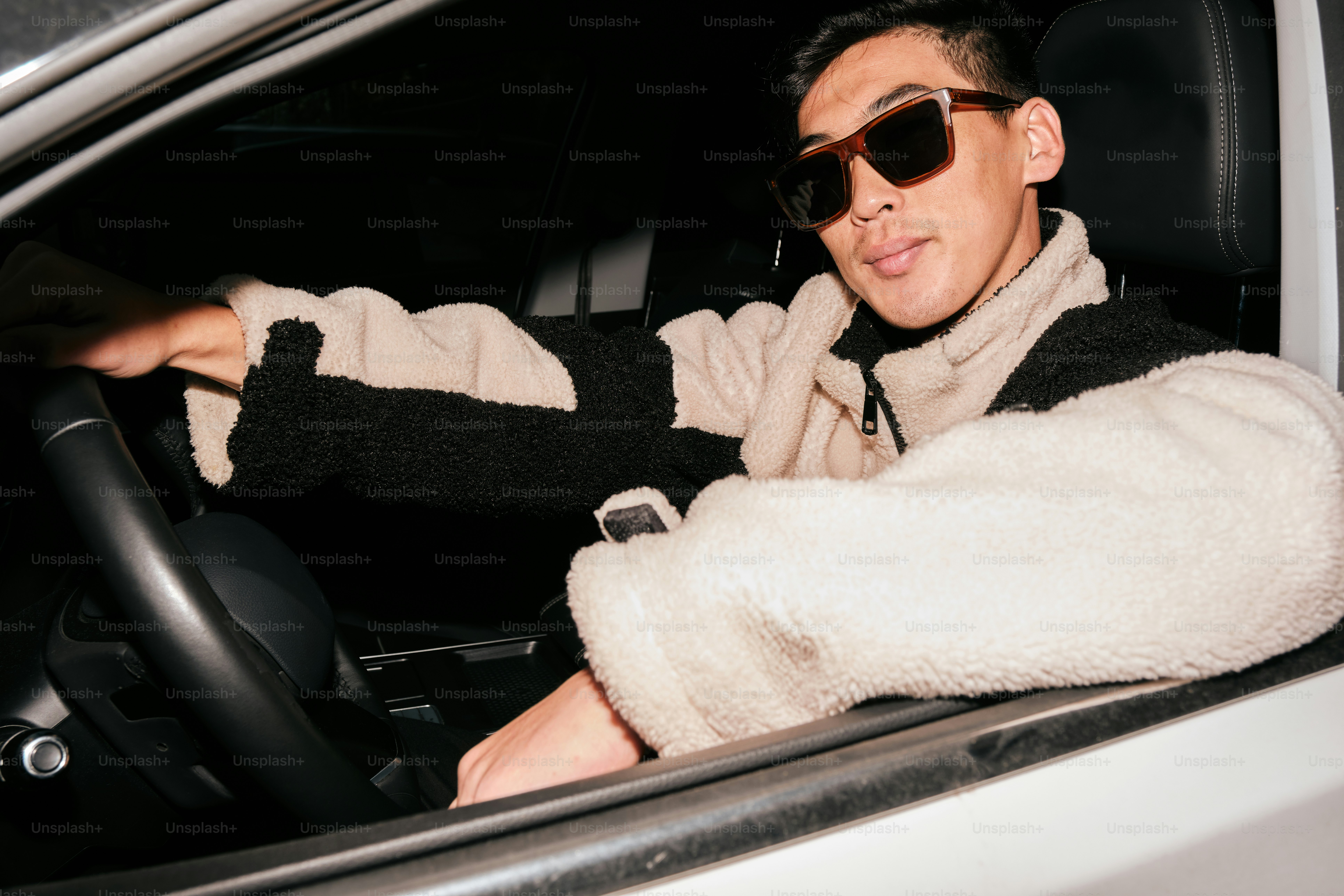 A man wearing sunglasses sitting in a car