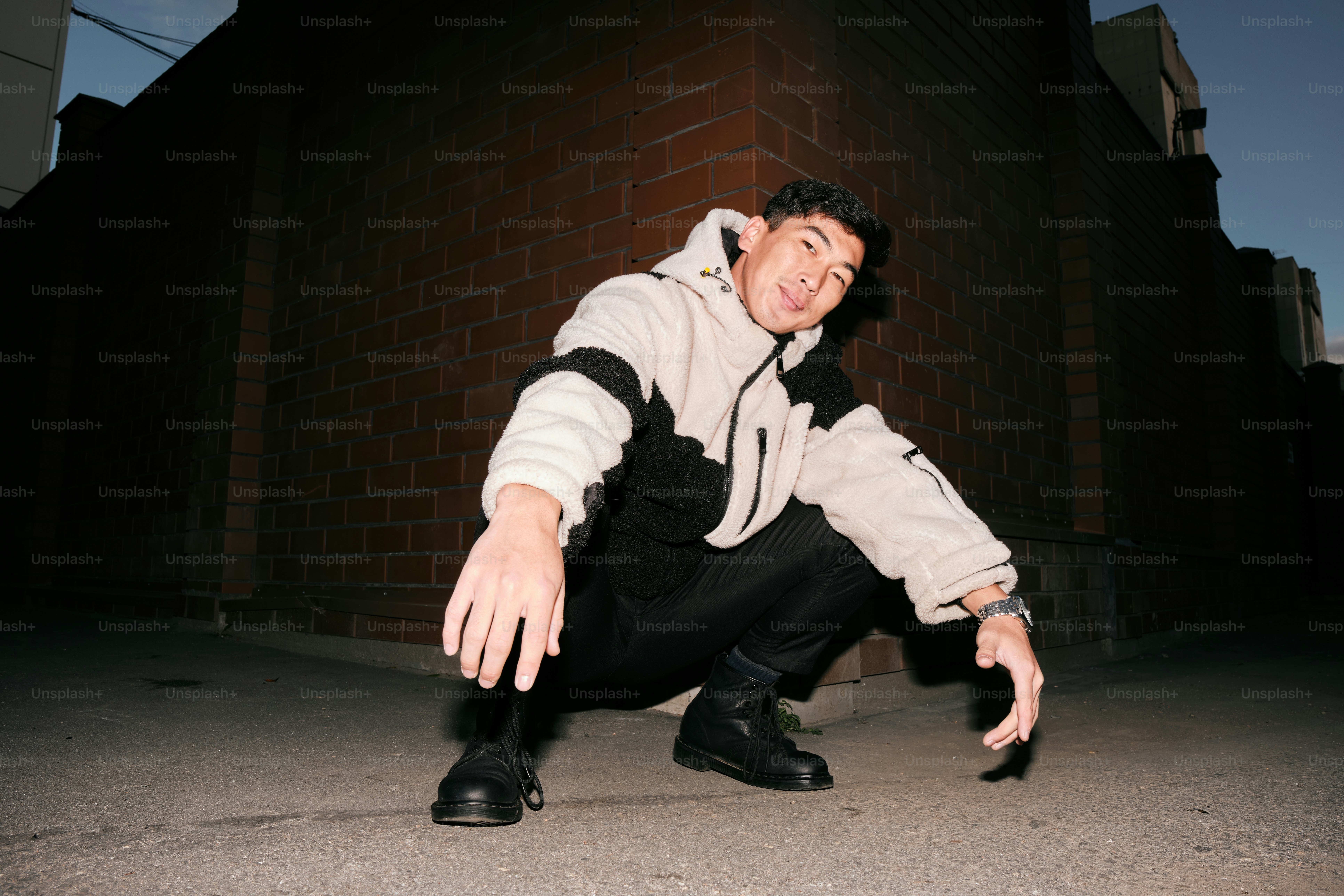 A man kneeling down on the ground in front of a building