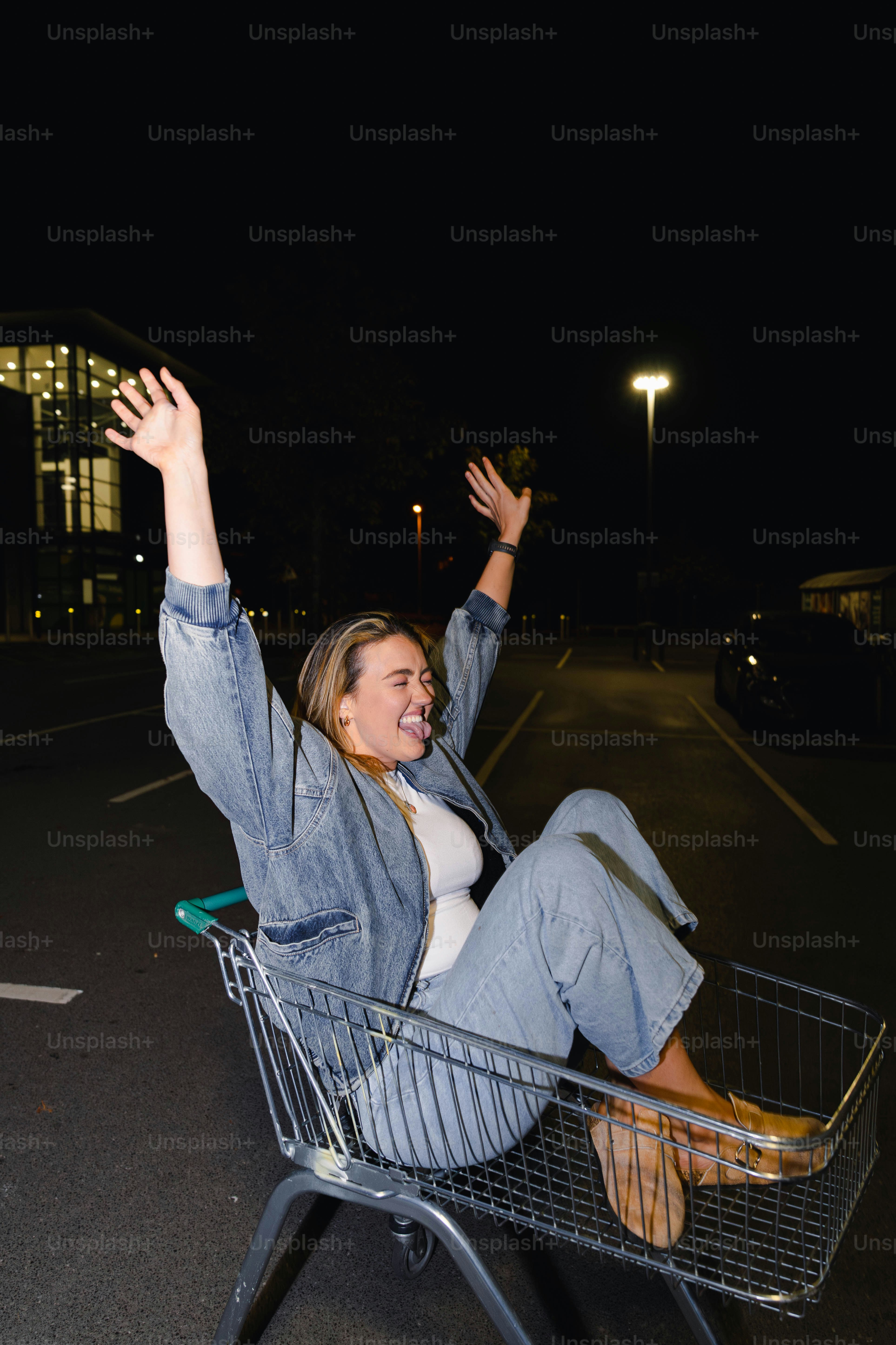 A woman sitting in a shopping cart waving