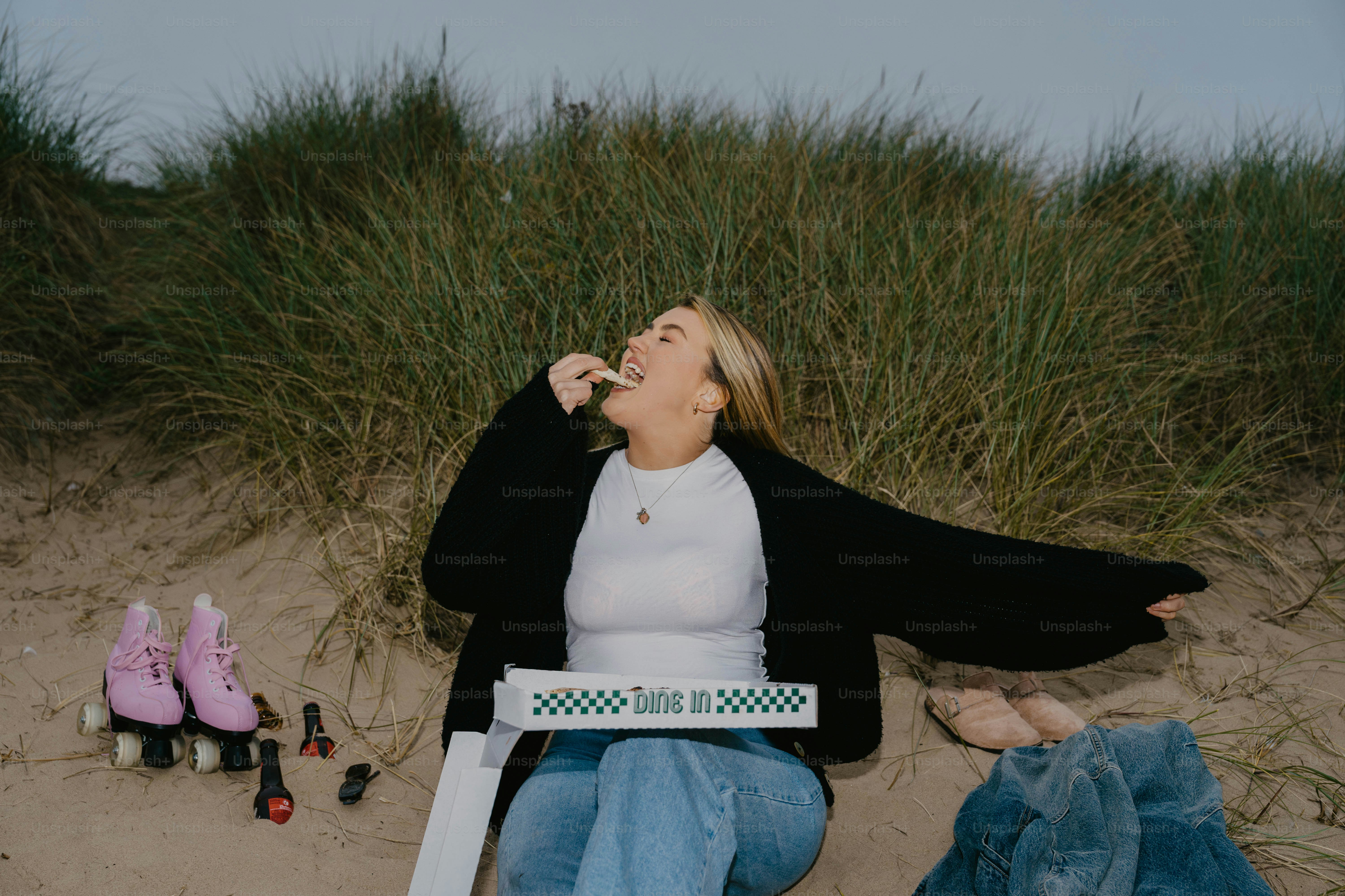 A woman sitting on a beach with her mouth open