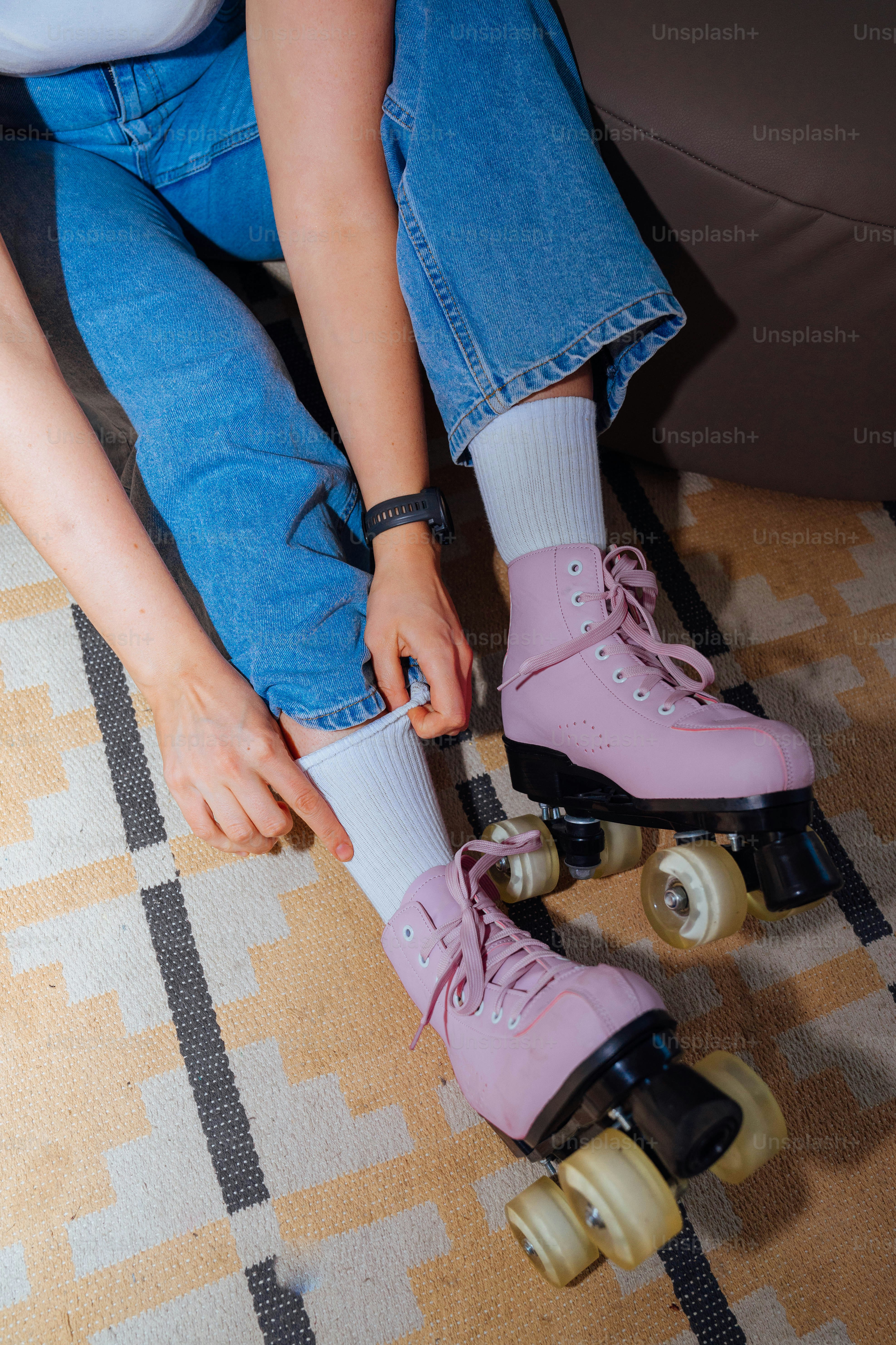 A person wearing pink roller skates on a carpet