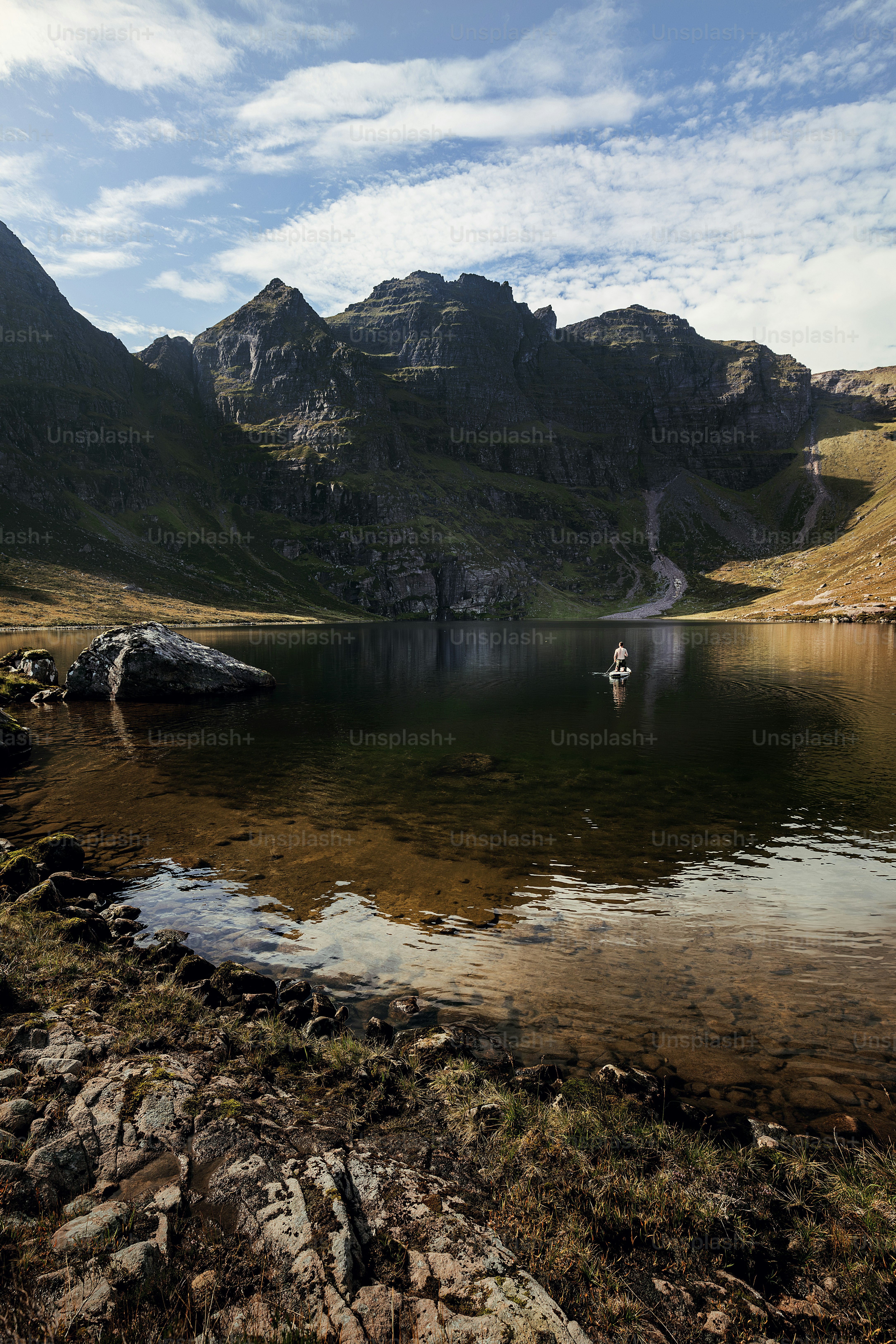 A lake surrounded by mountains under a blue sky