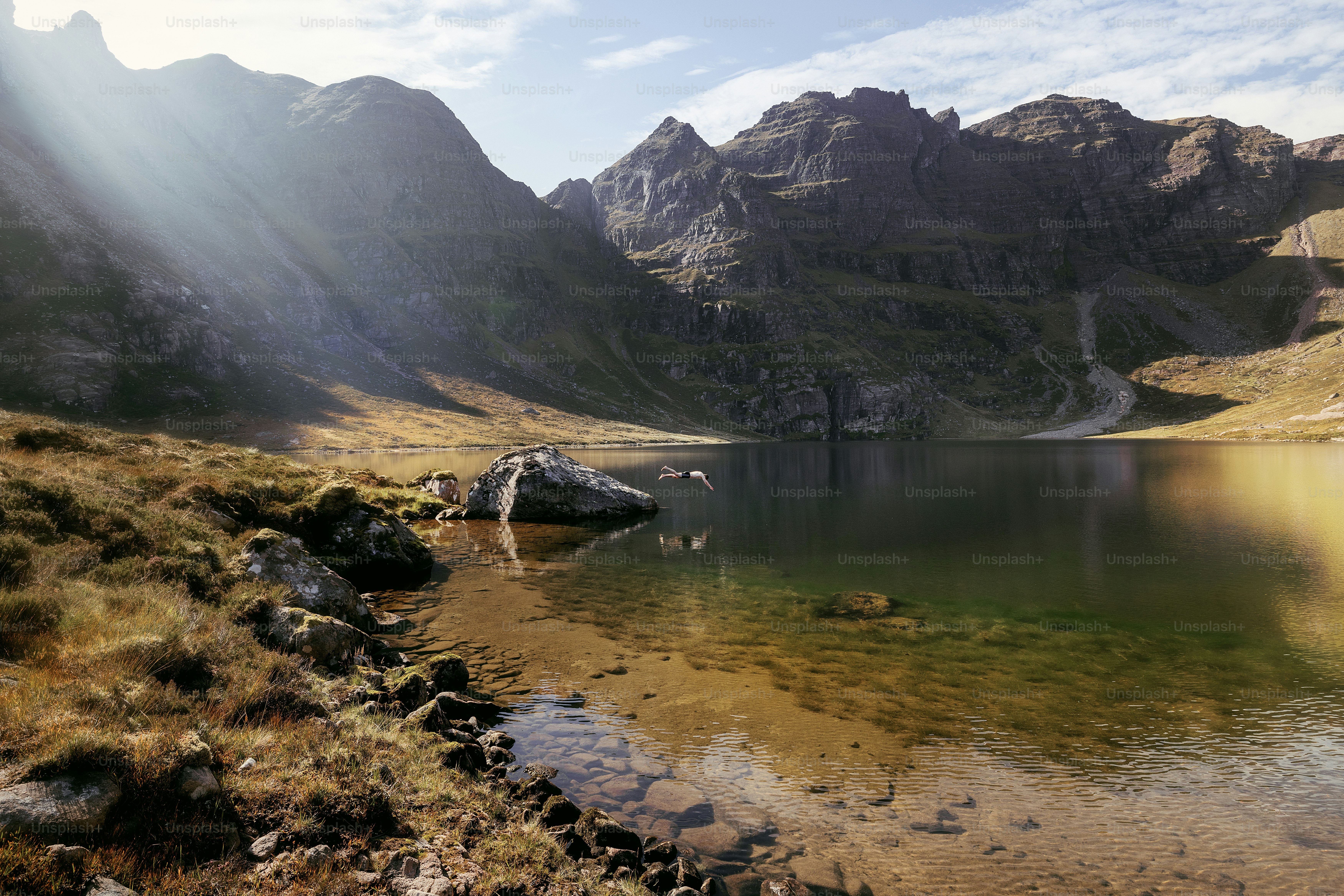 A lake surrounded by mountains and rocks on a sunny day
