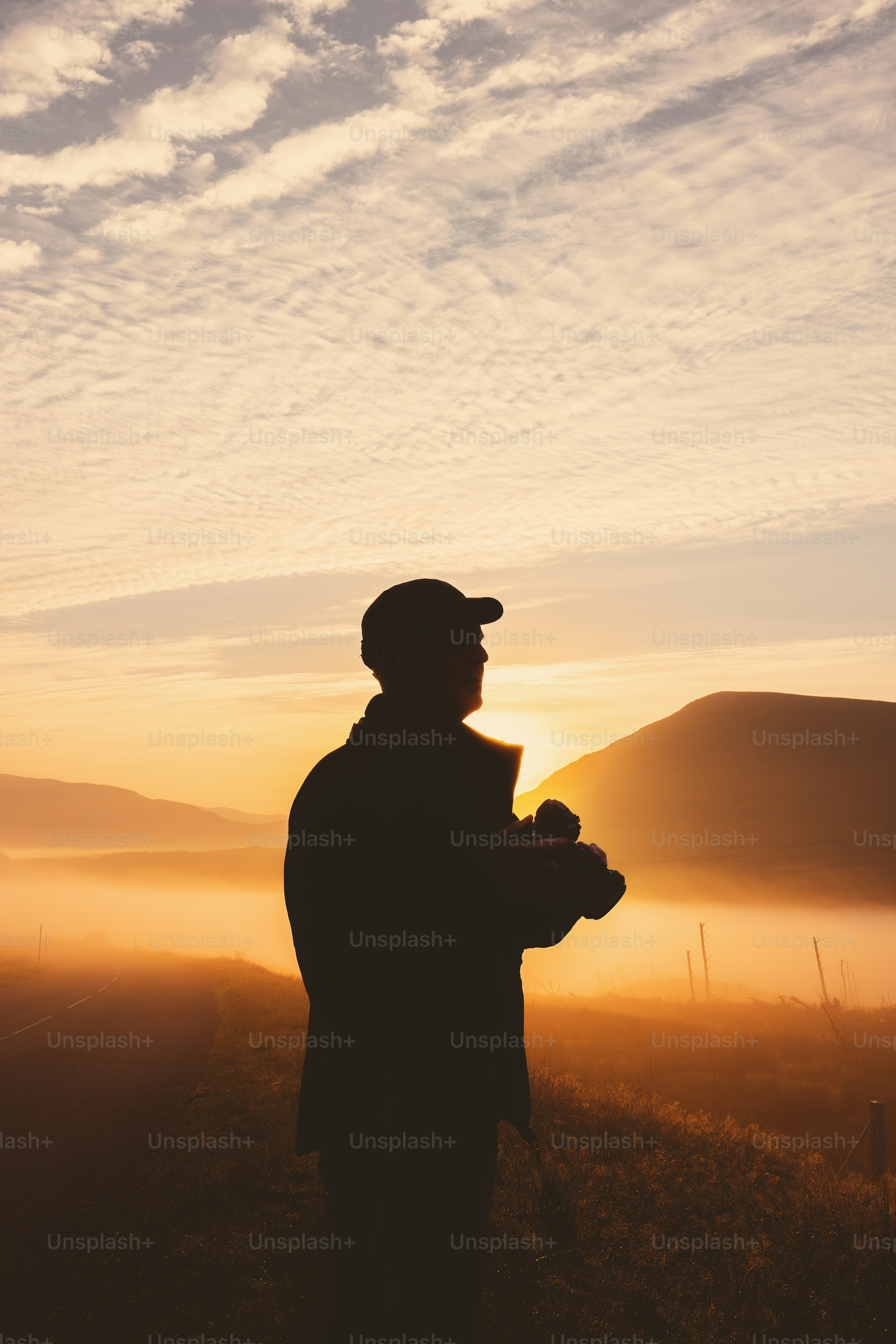 Un hombre de pie en un campo al atardecer