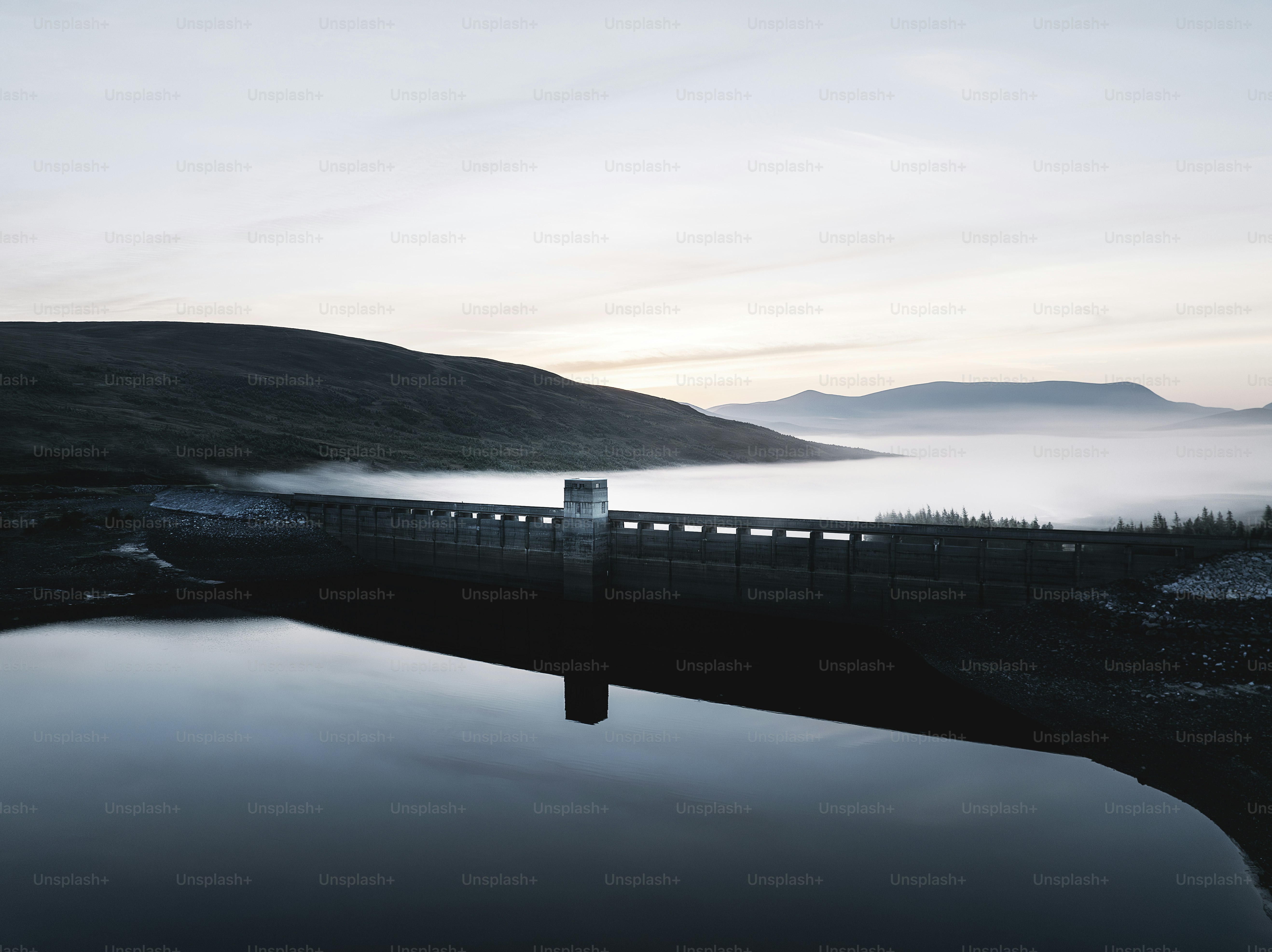 Un plan d’eau entouré de montagnes et de brouillard