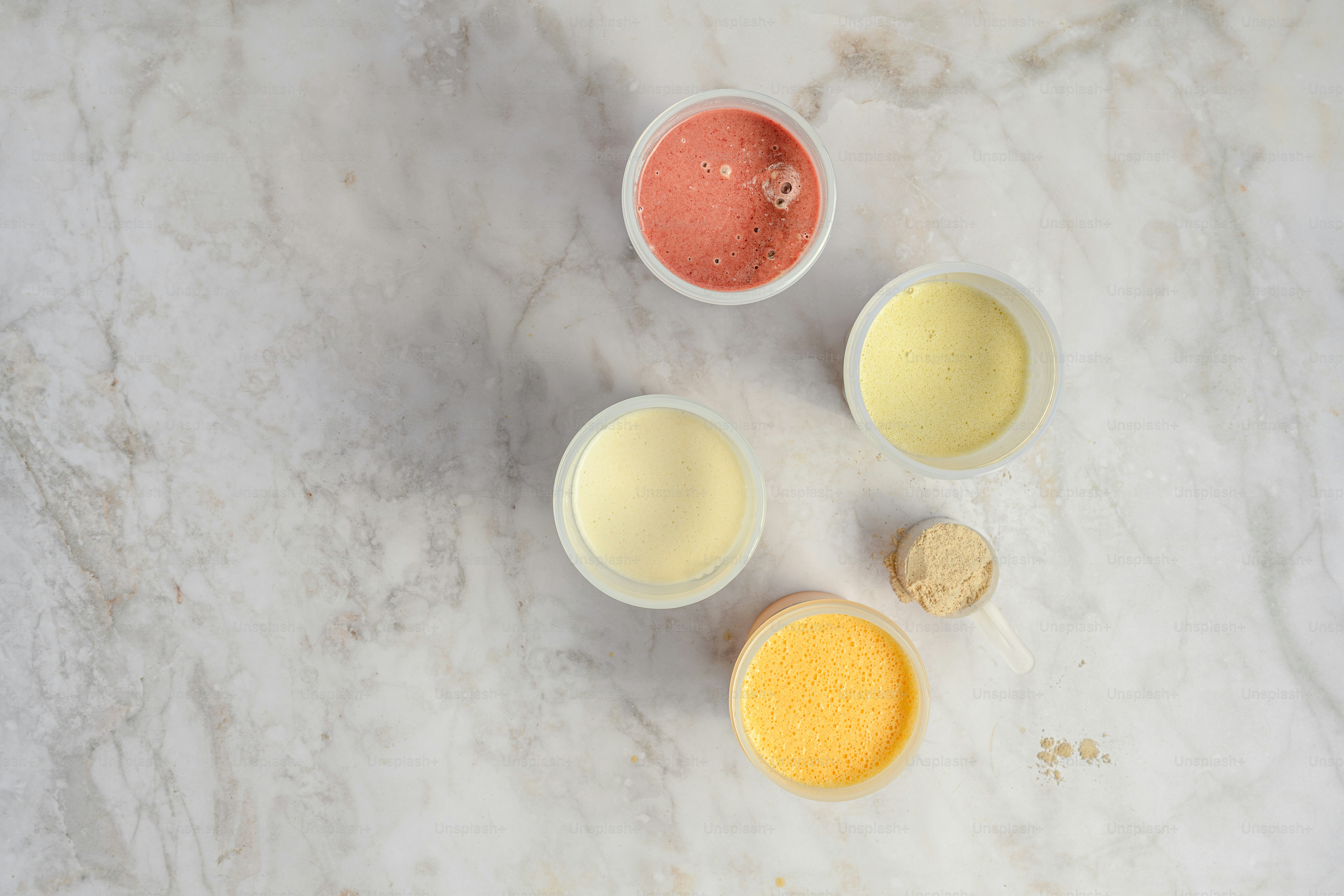A marble counter top with four different colors of paint
