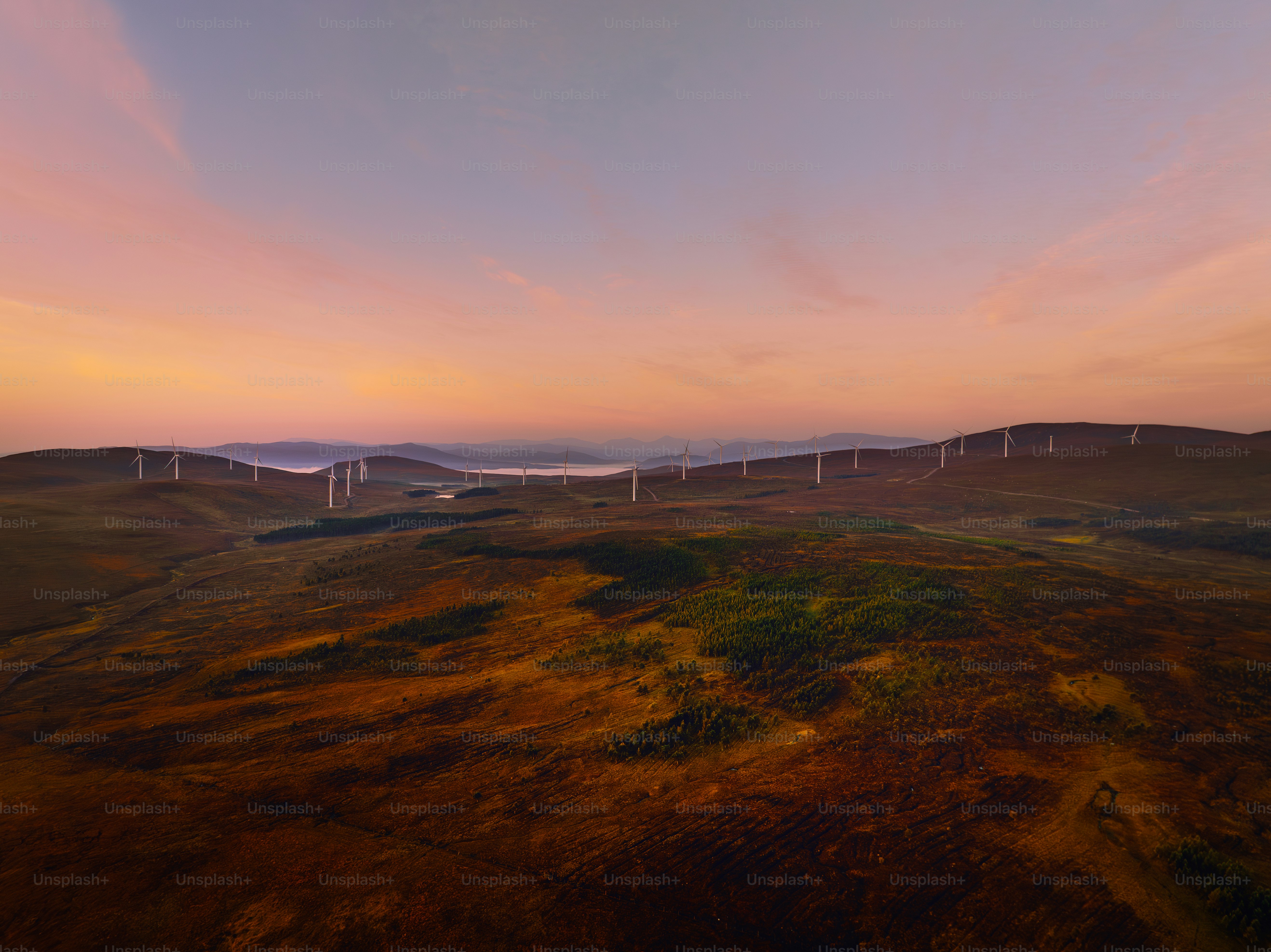 Une vue aérienne d’un parc éolien au coucher du soleil