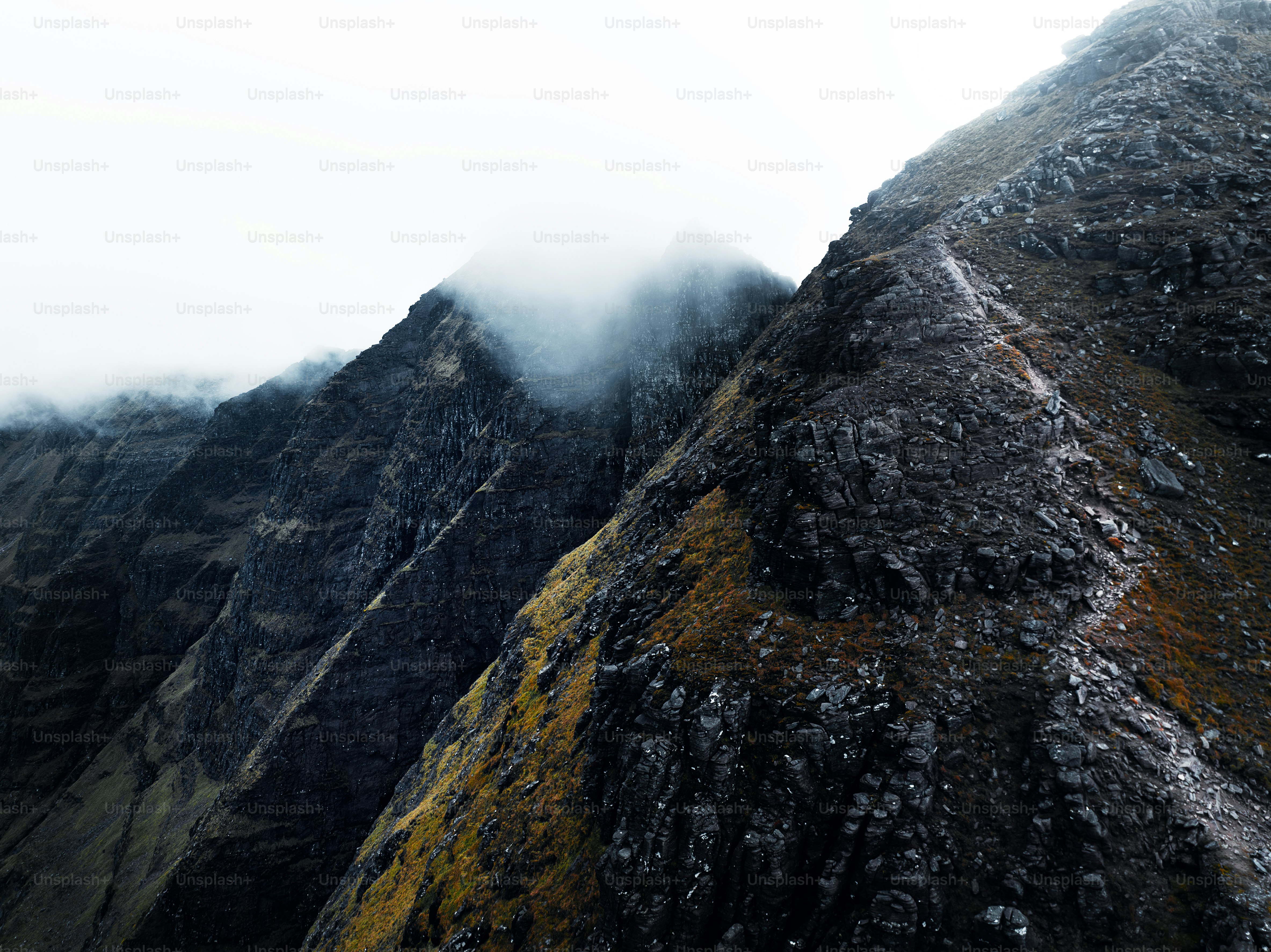 A mountain covered in snow and fog on a cloudy day