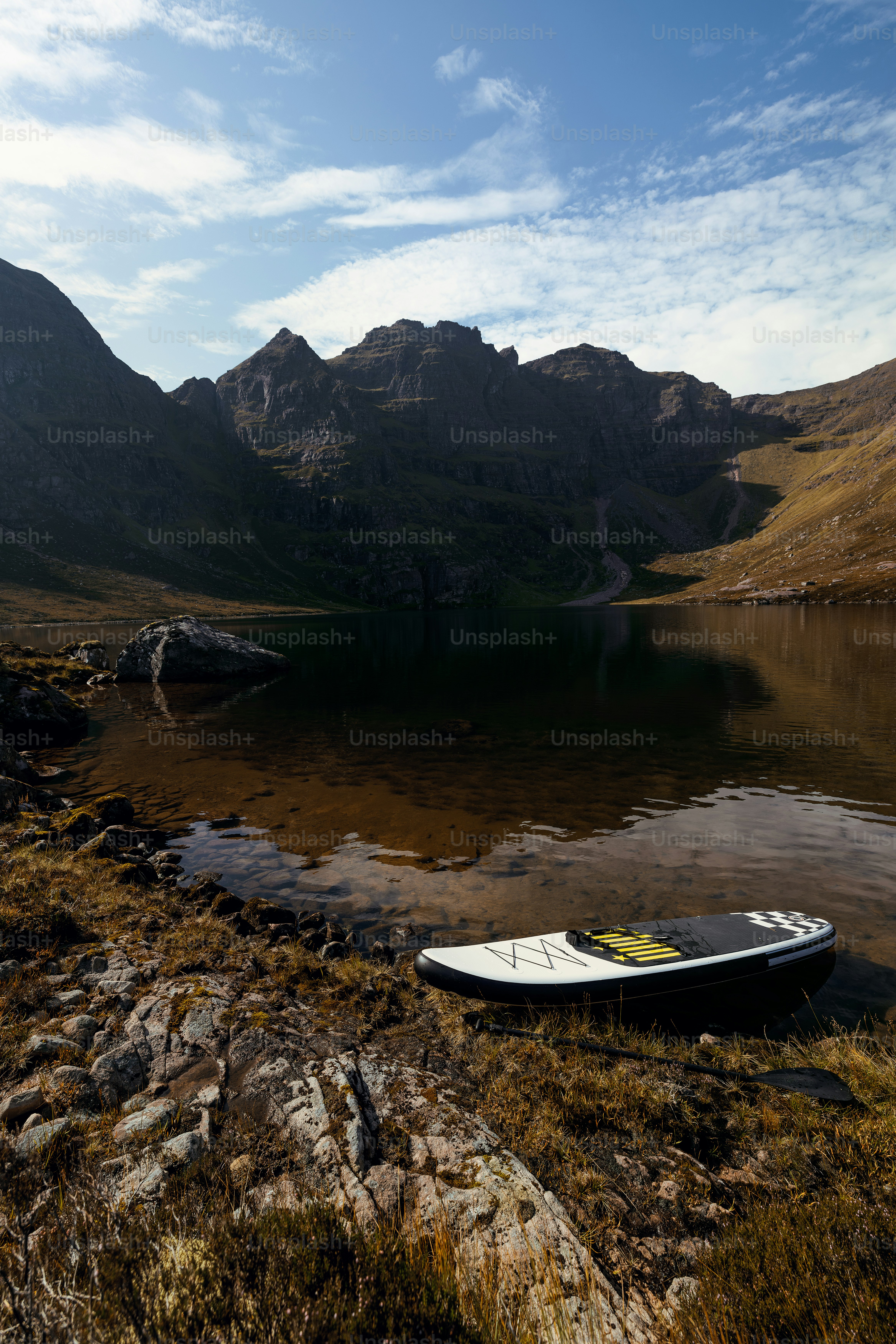 A boat sitting on the shore of a mountain lake