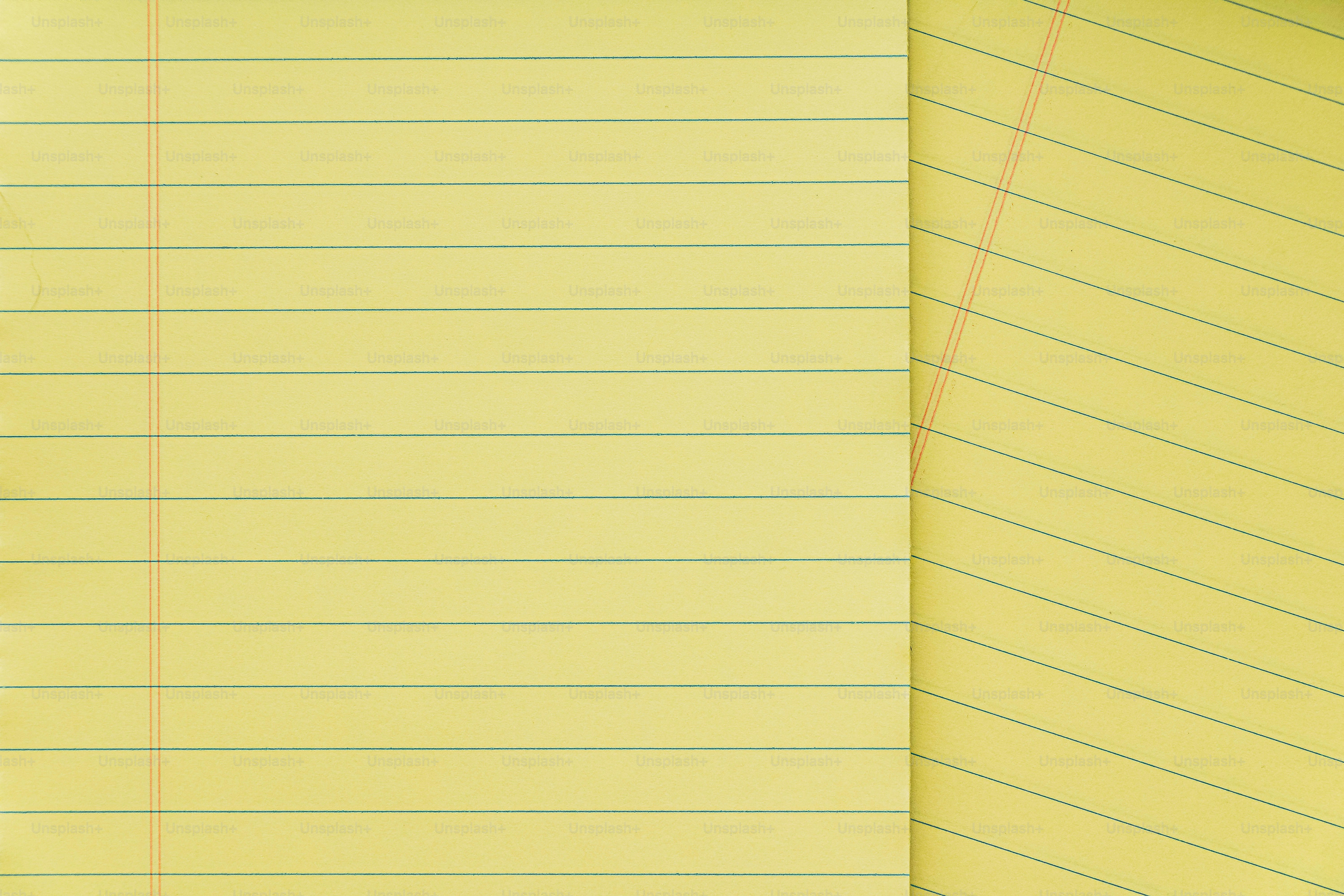 A yellow lined paper with a pencil on top of it