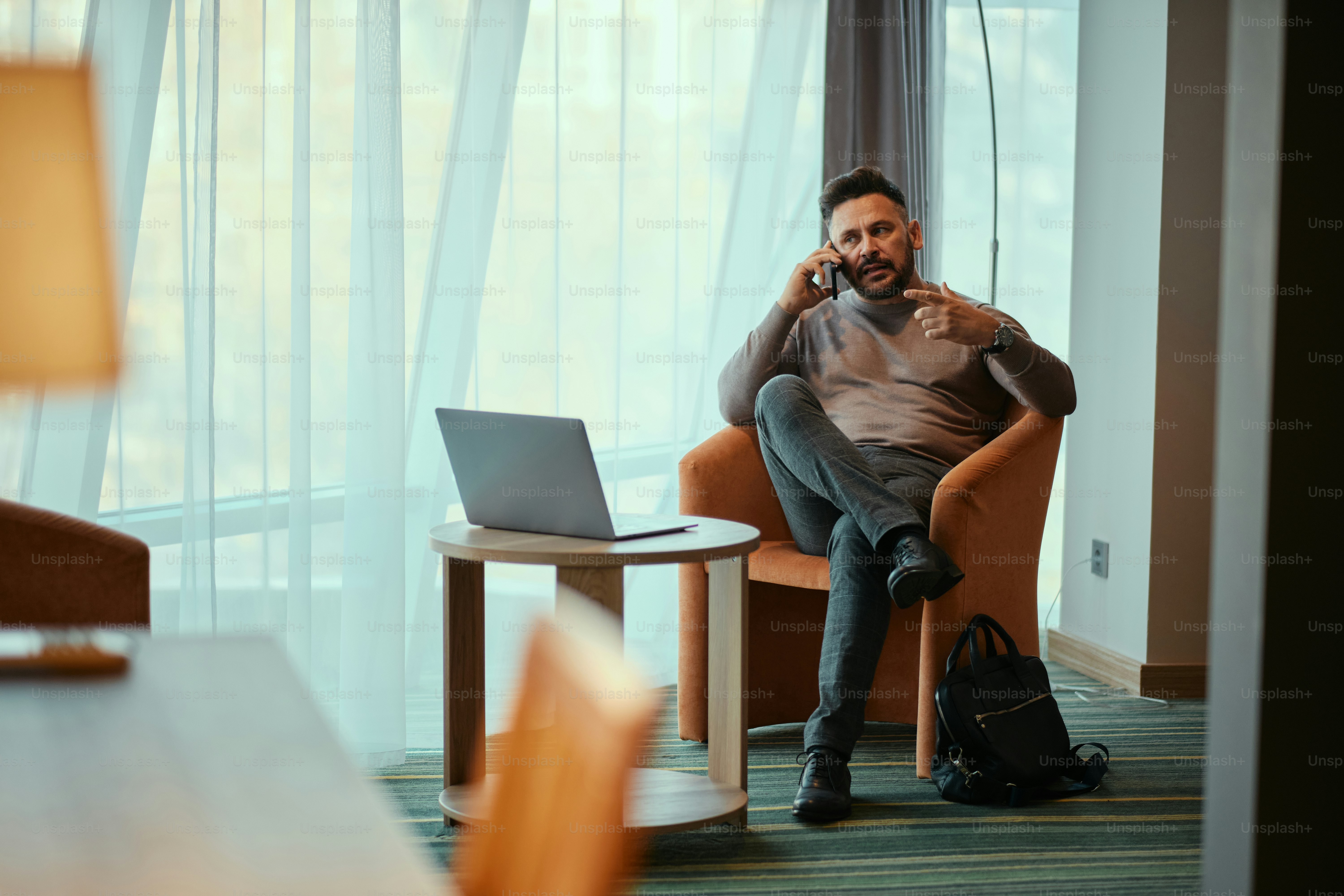 A man sitting in a chair talking on a cell phone
