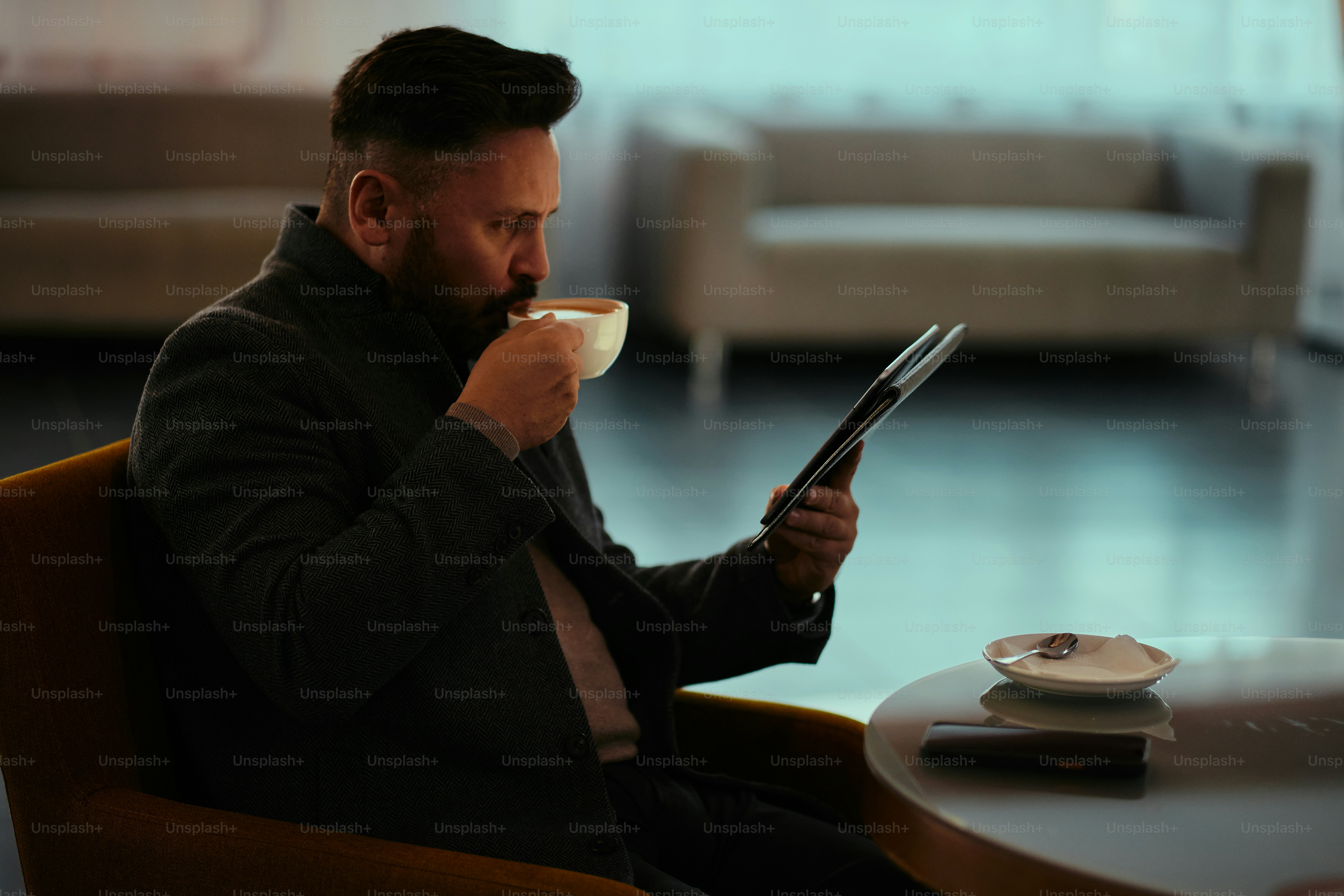 Ein Mann sitzt auf einem Stuhl und hält ein Tablet in der Hand