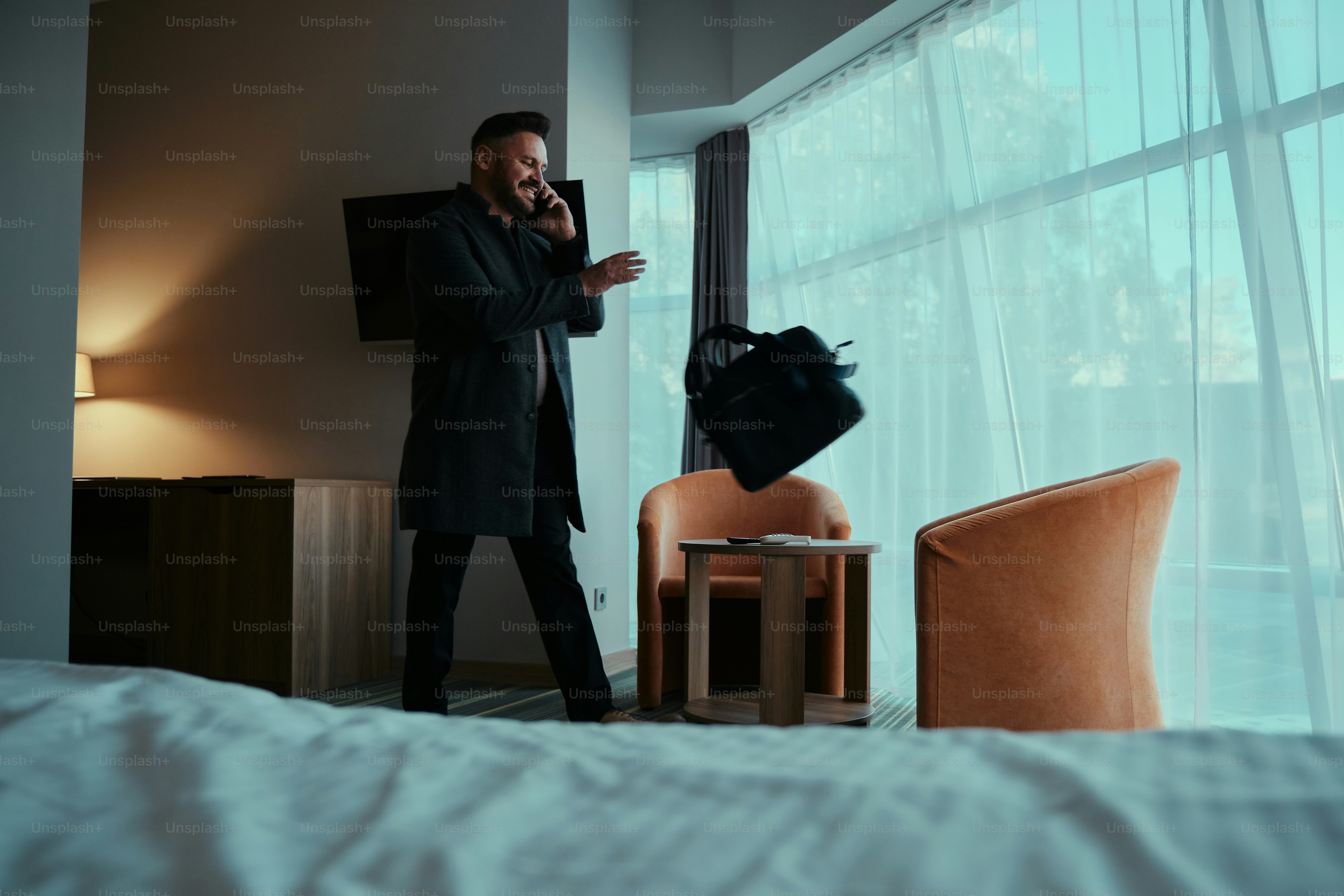 A man in a suit standing next to a window photo – Business travel Image ...