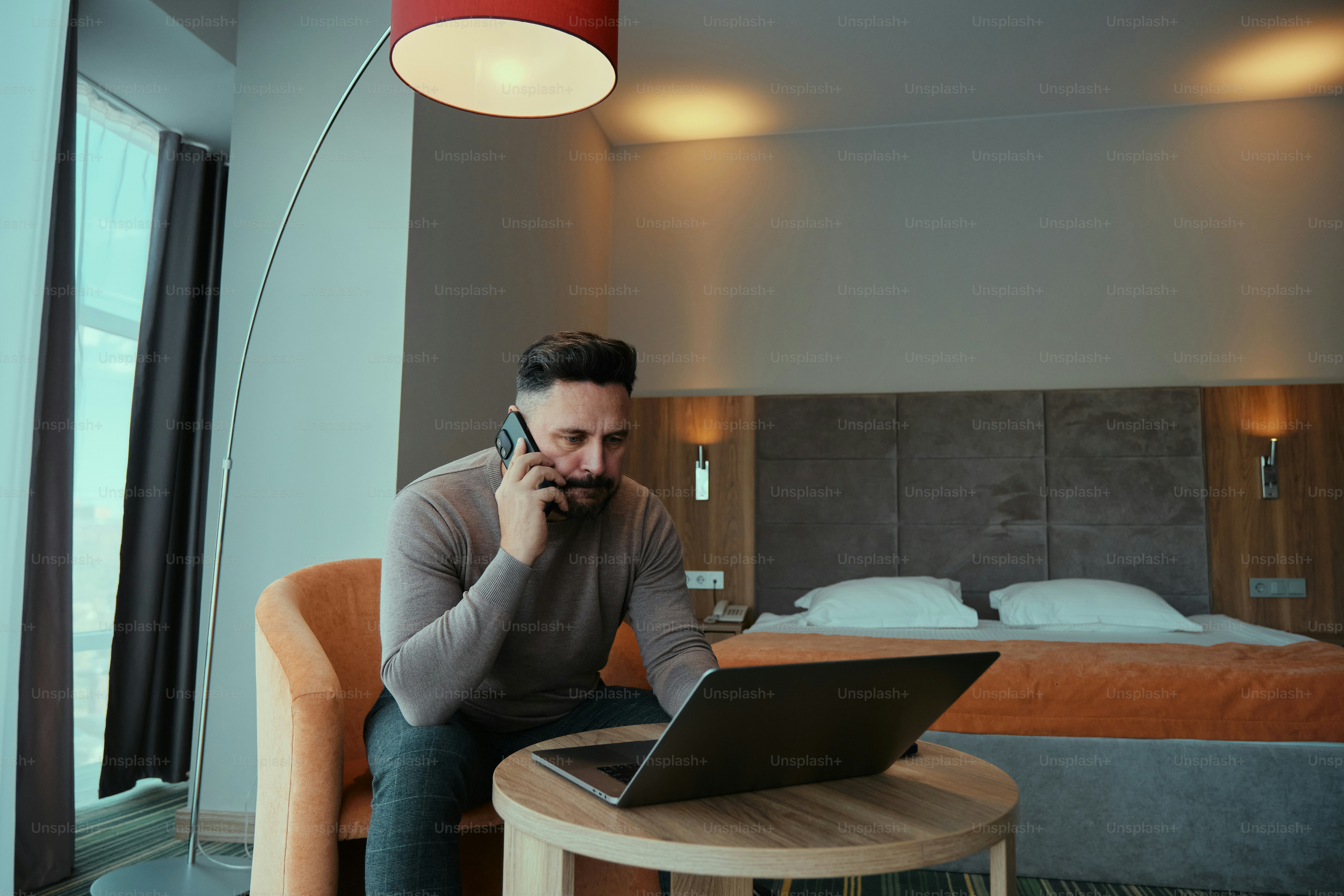A man sitting in a chair using a laptop computer
