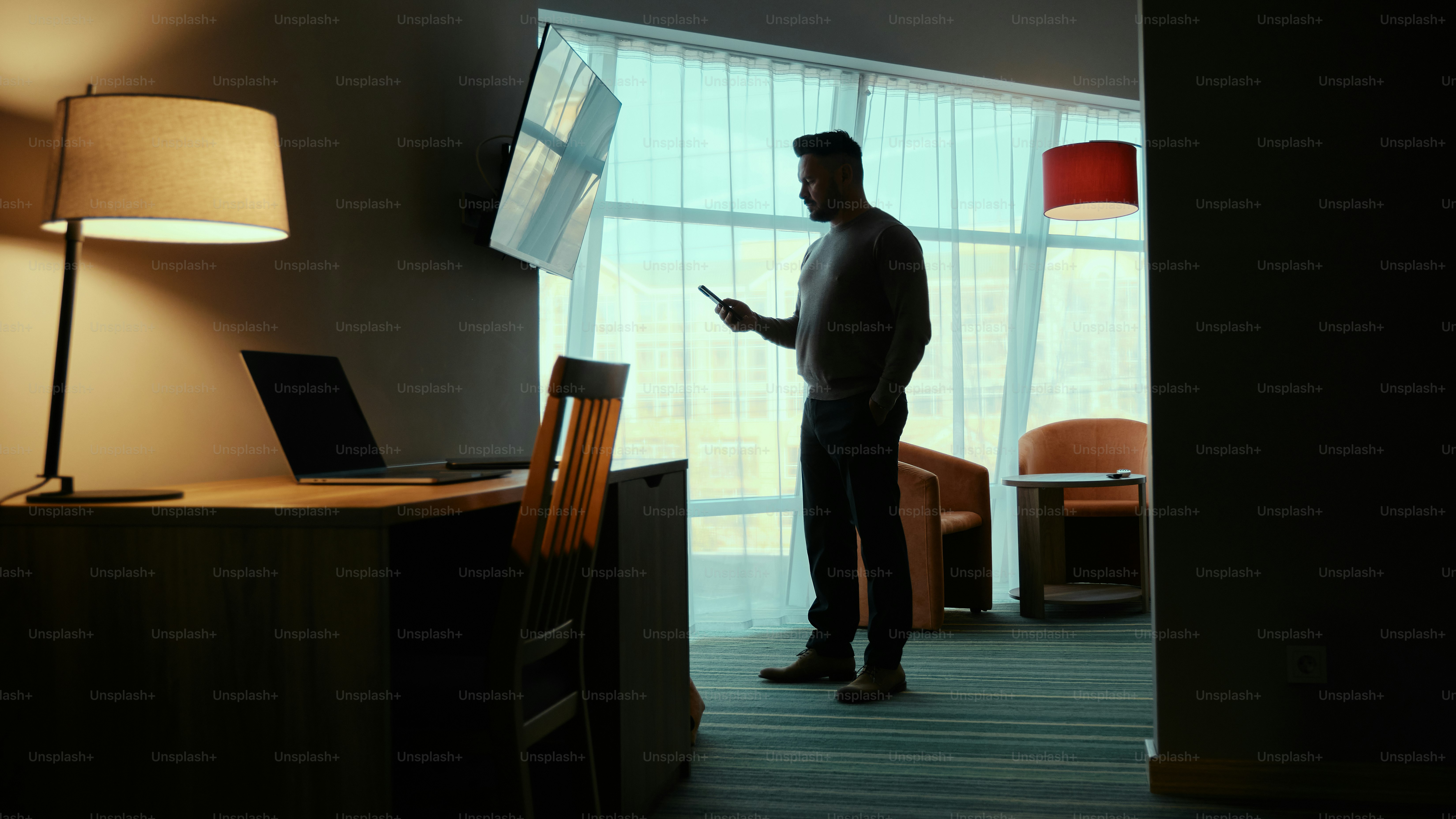 A man standing in a room next to a lamp