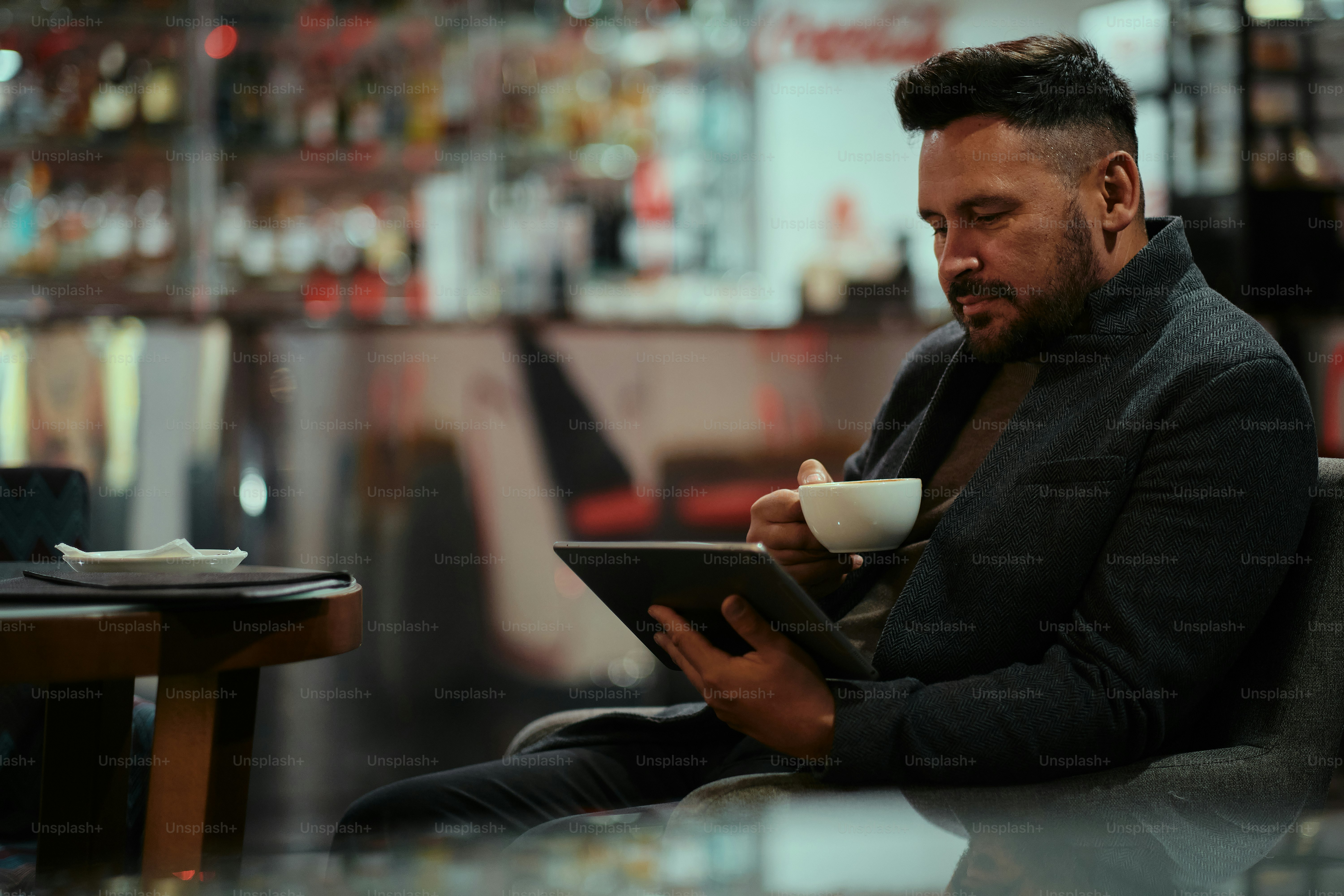 A man sitting at a table using a tablet