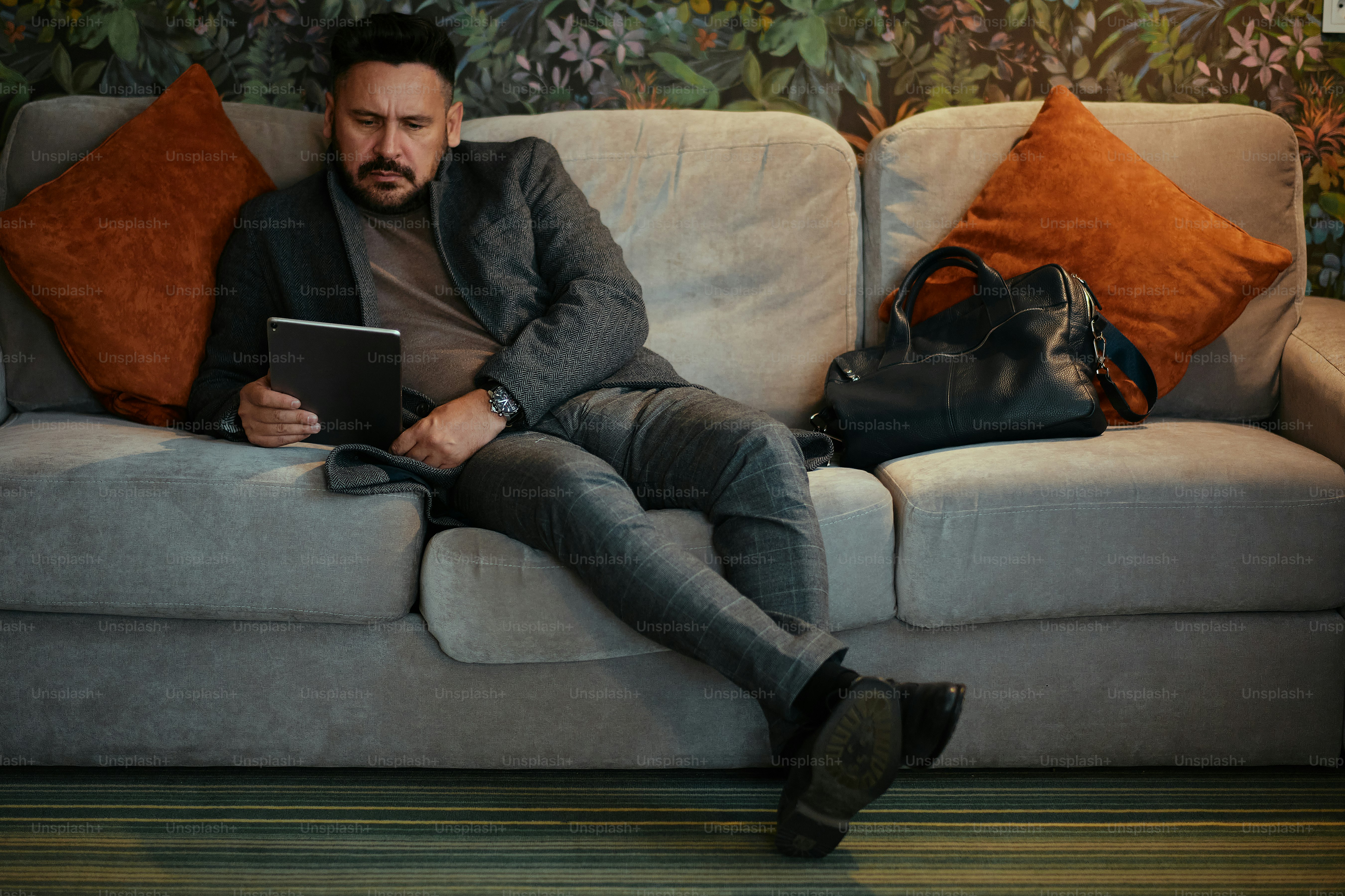 Ein Mann sitzt mit einem Laptop auf einer Couch