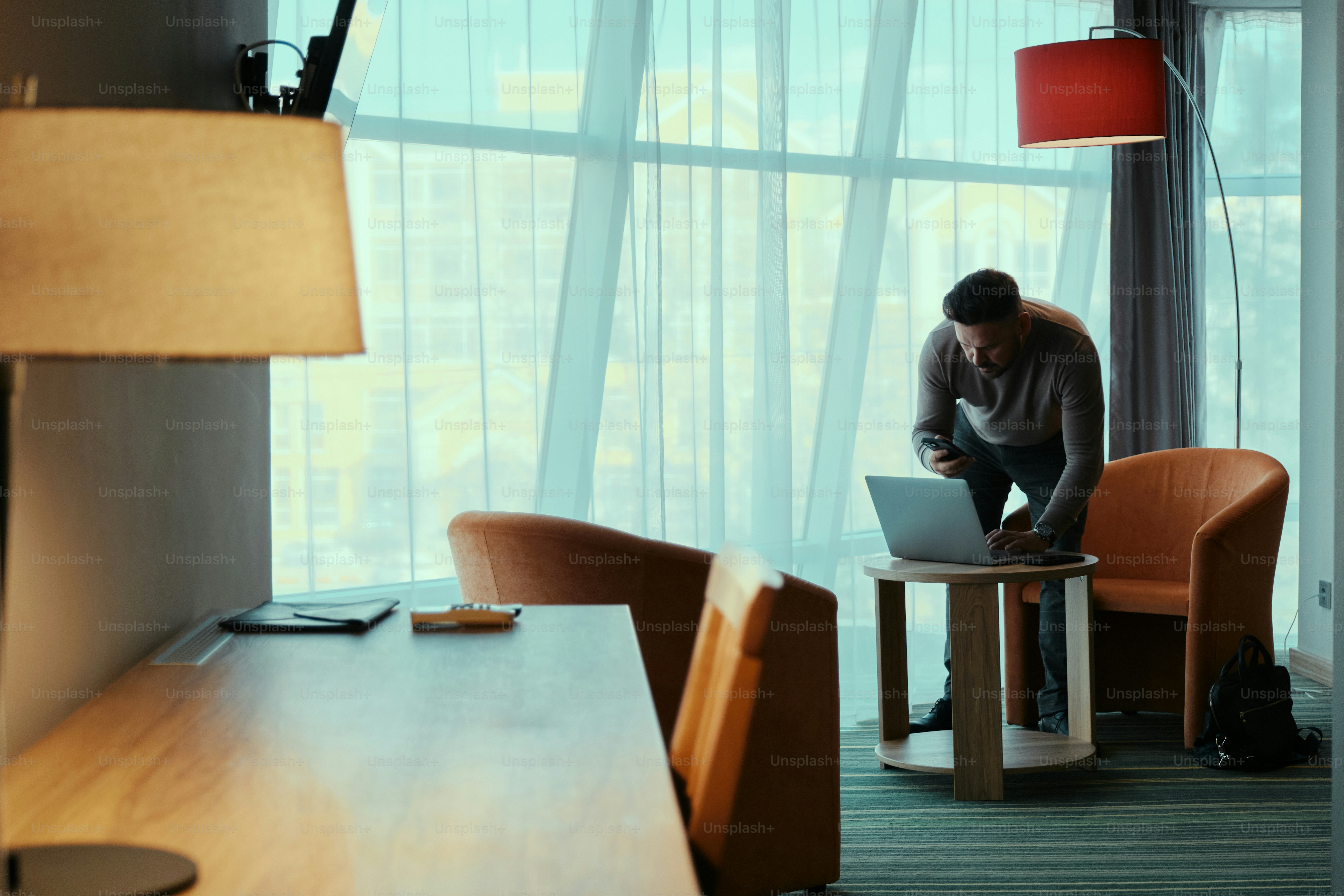 Ein Mann, der auf einem Stuhl sitzt und einen Laptop benutzt