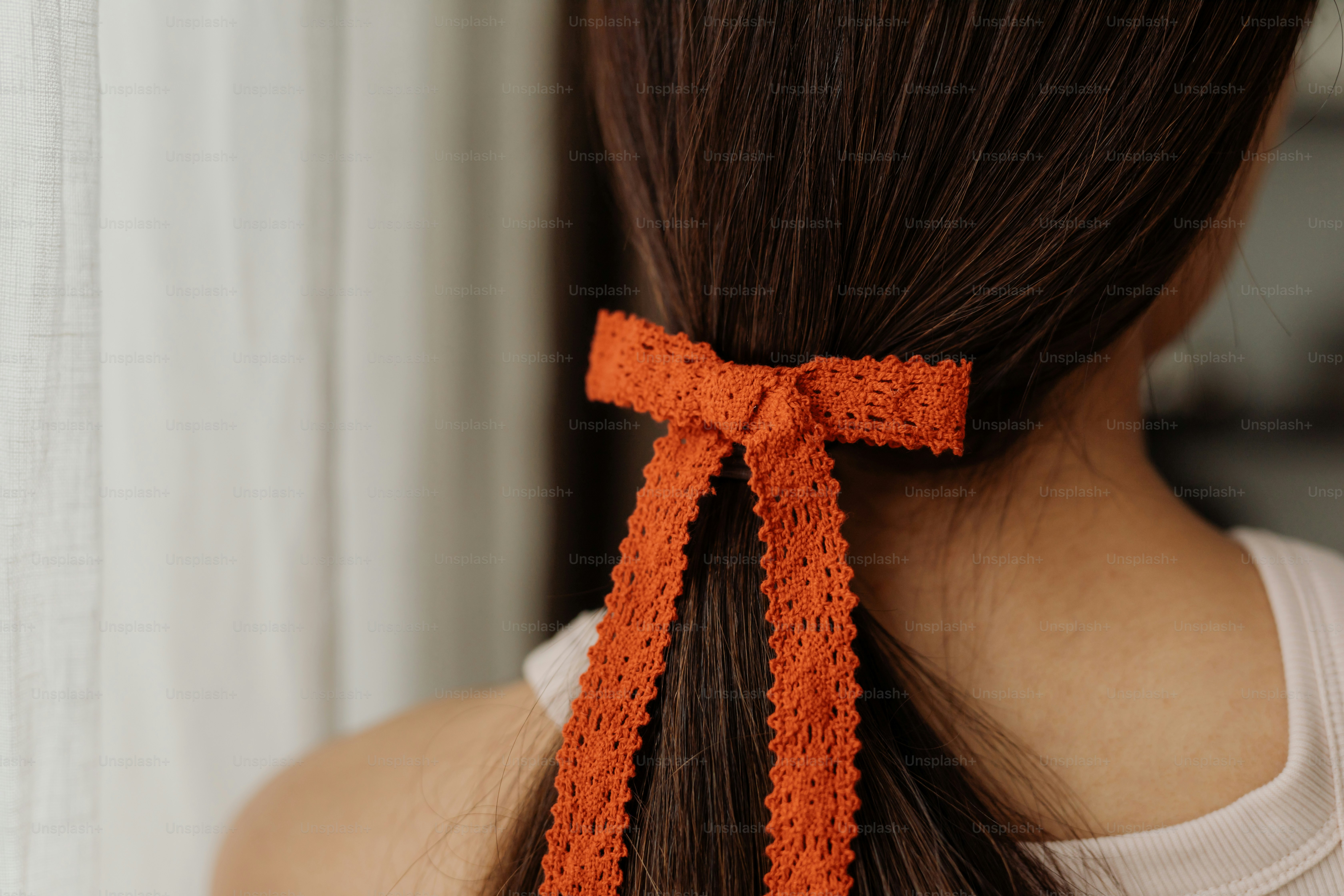 A woman with long hair wearing an orange bow
