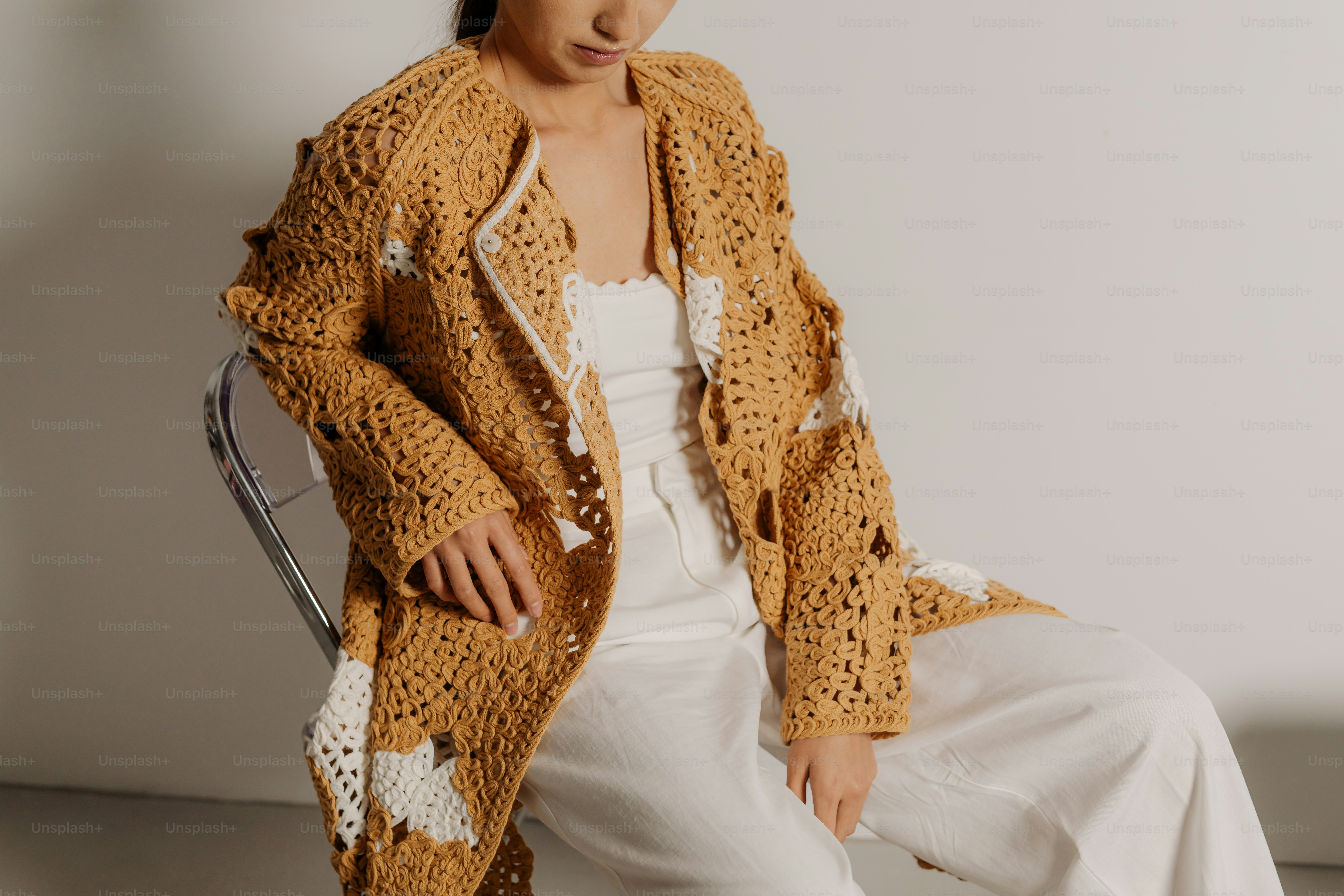 Uma mulher sentada em uma cadeira em uma sala branca