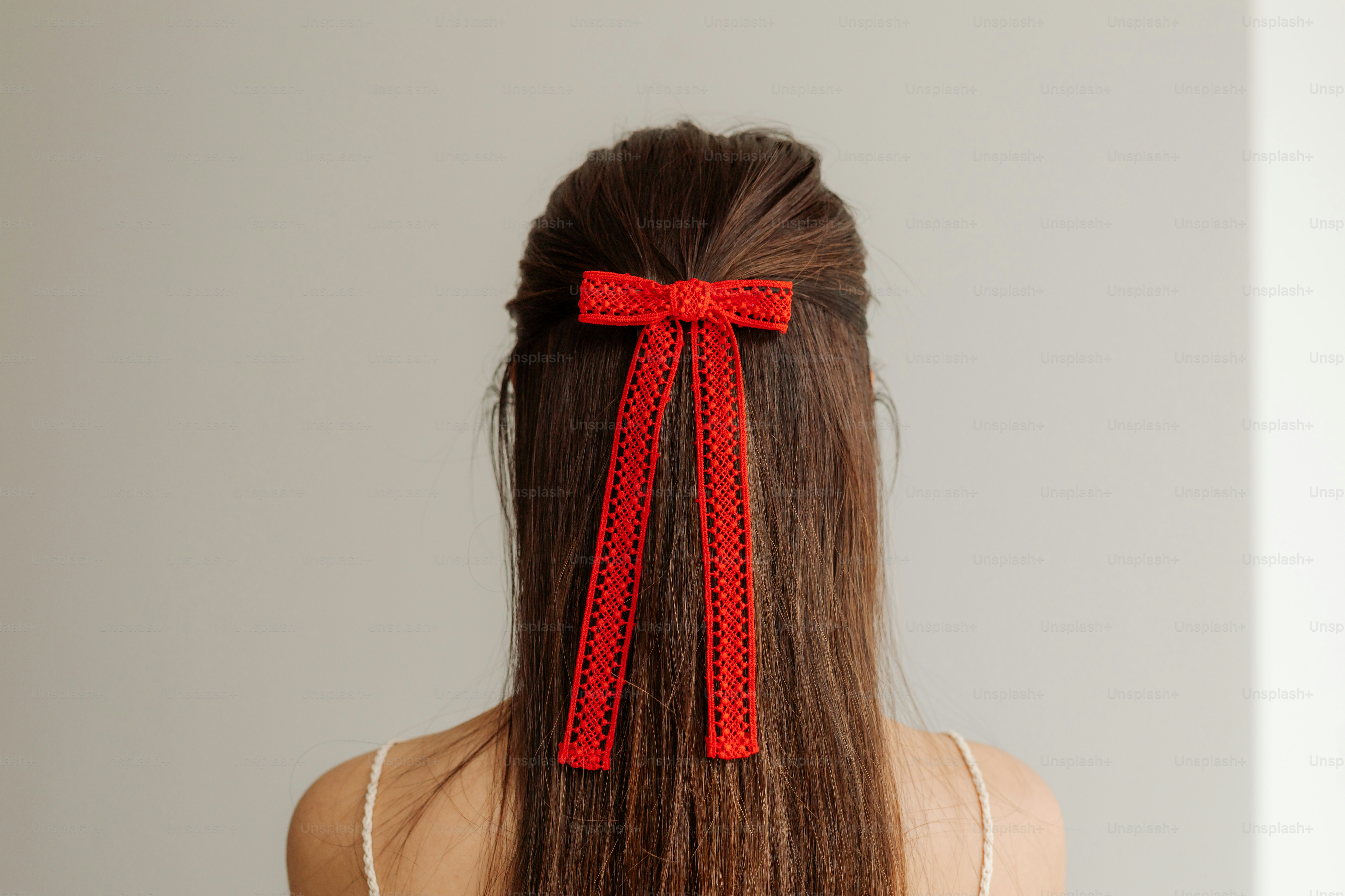 A woman with long hair wearing a red bow