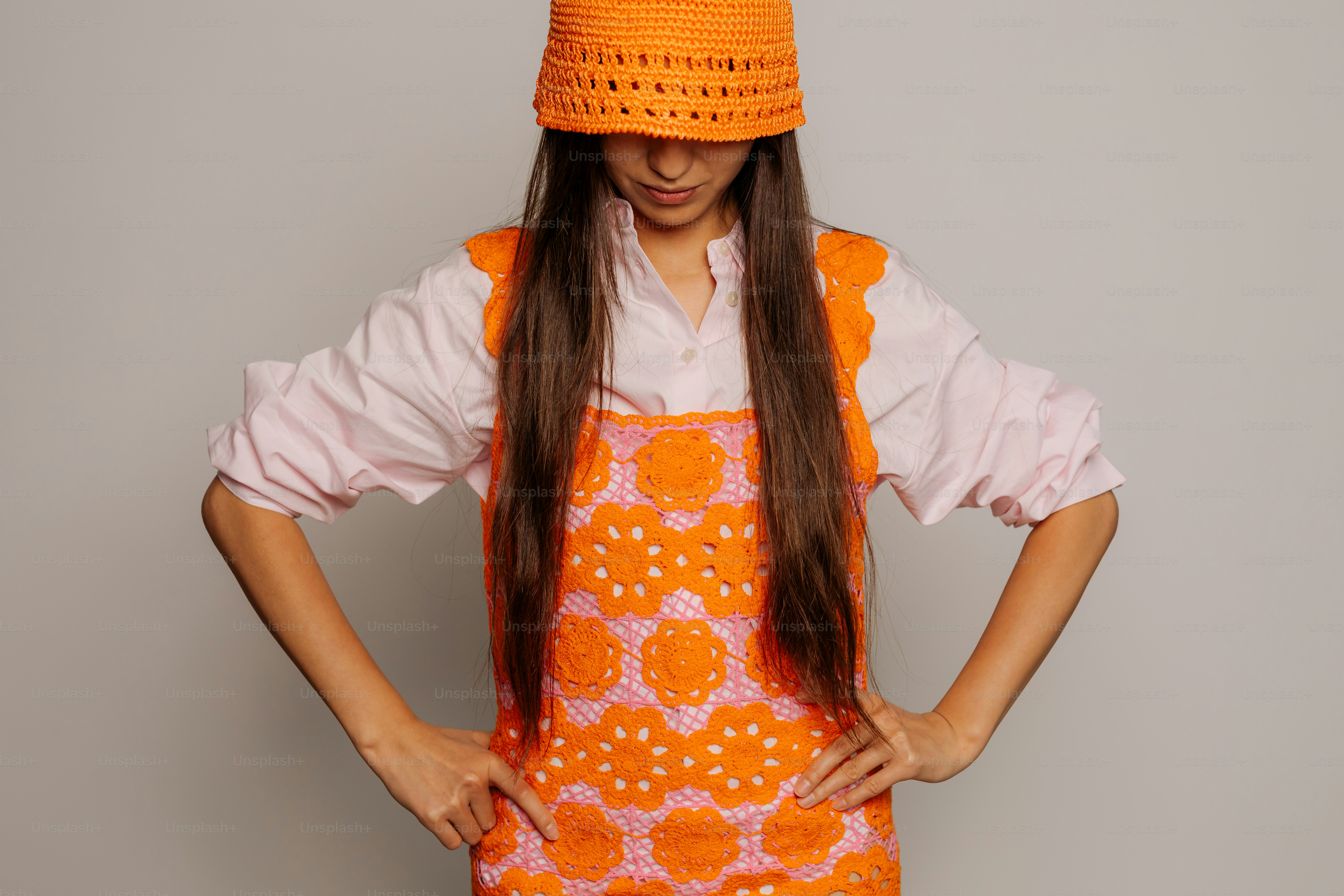 A woman wearing an orange and white apron and hat