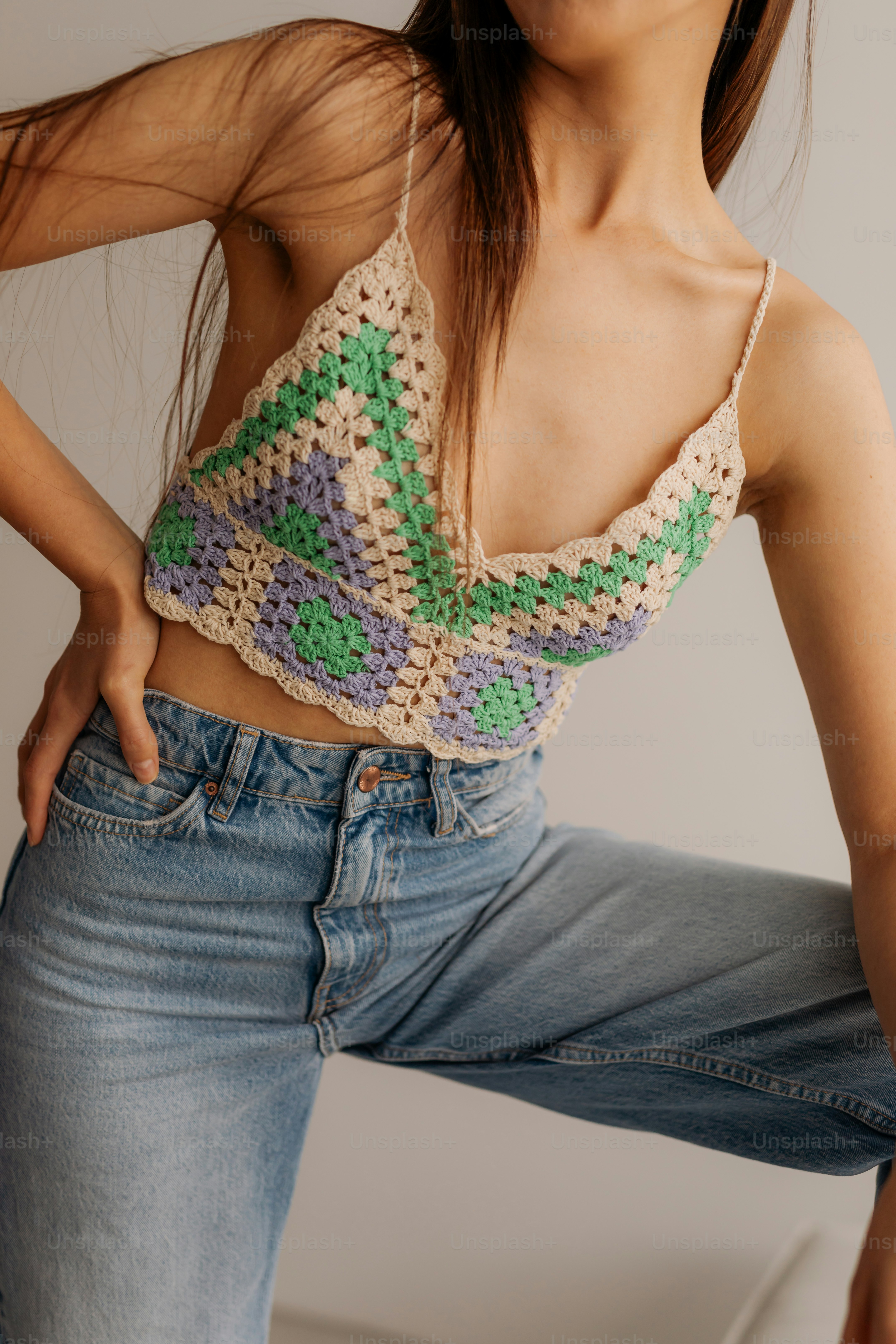 A woman in a crochet top poses for a picture
