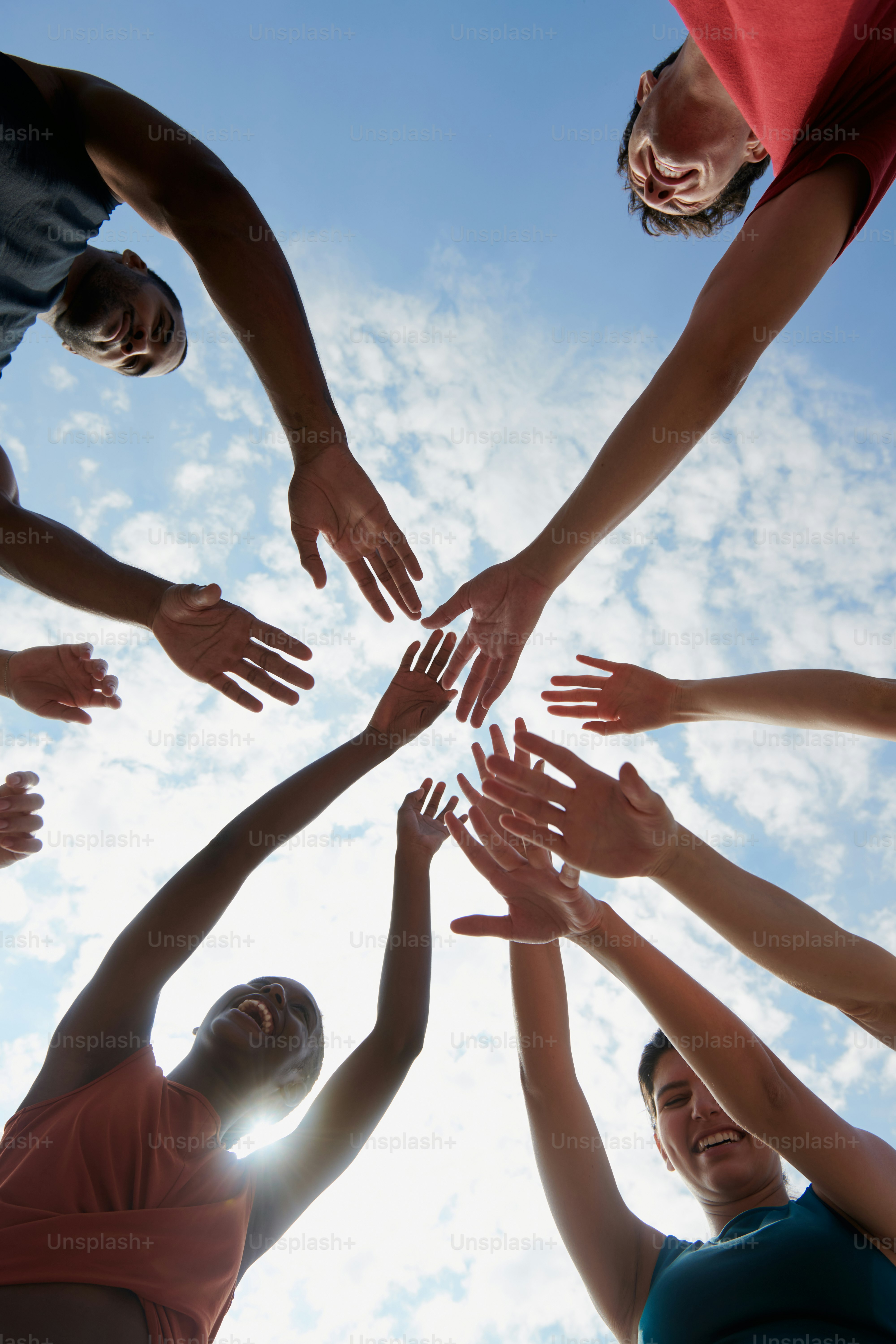 A group of people standing in a circle with their hands together