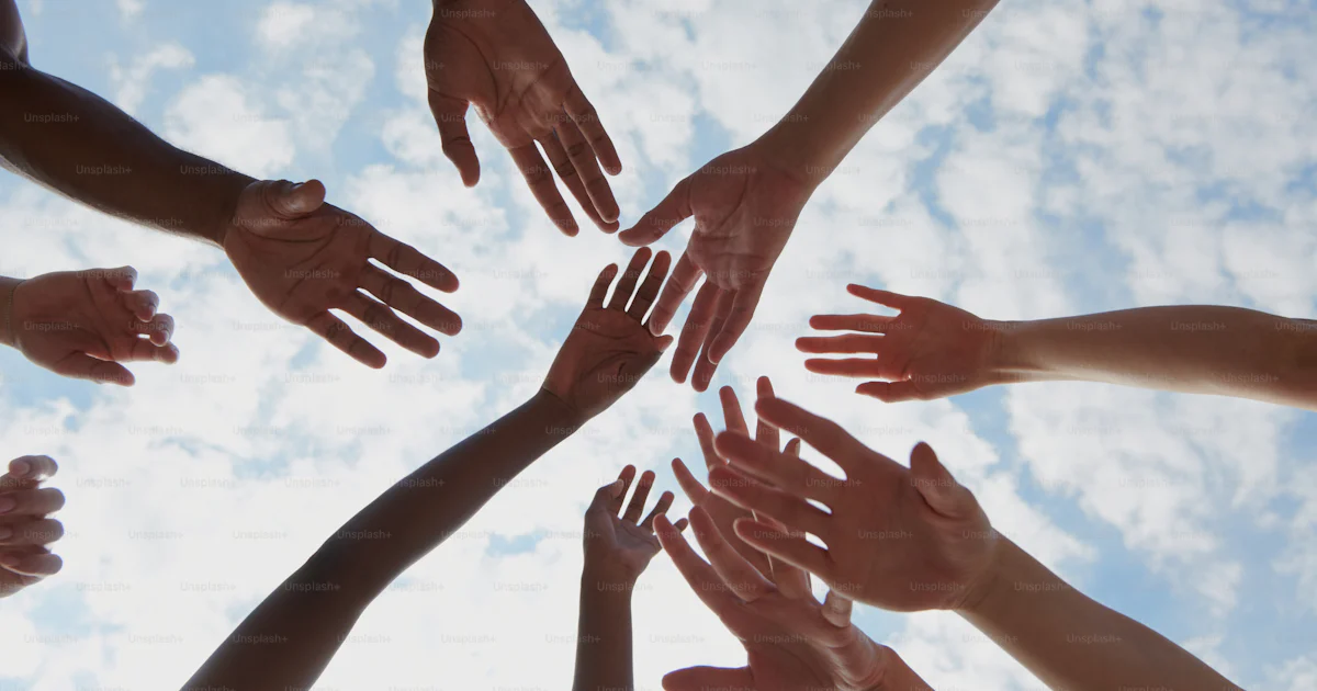 Un groupe de personnes debout en cercle, les mains jointes photo ...