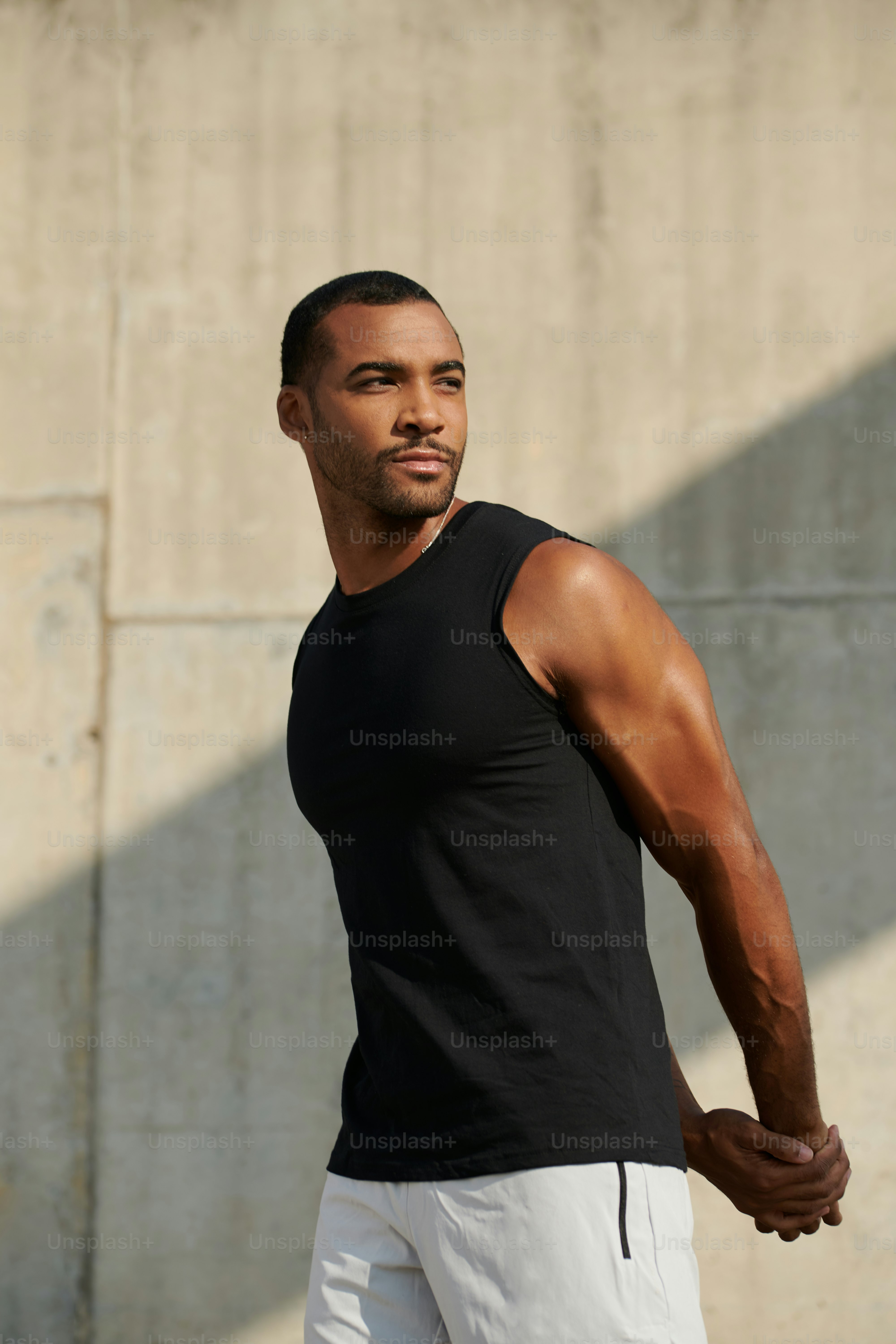 Un hombre con camisa negra y pantalones cortos blancos