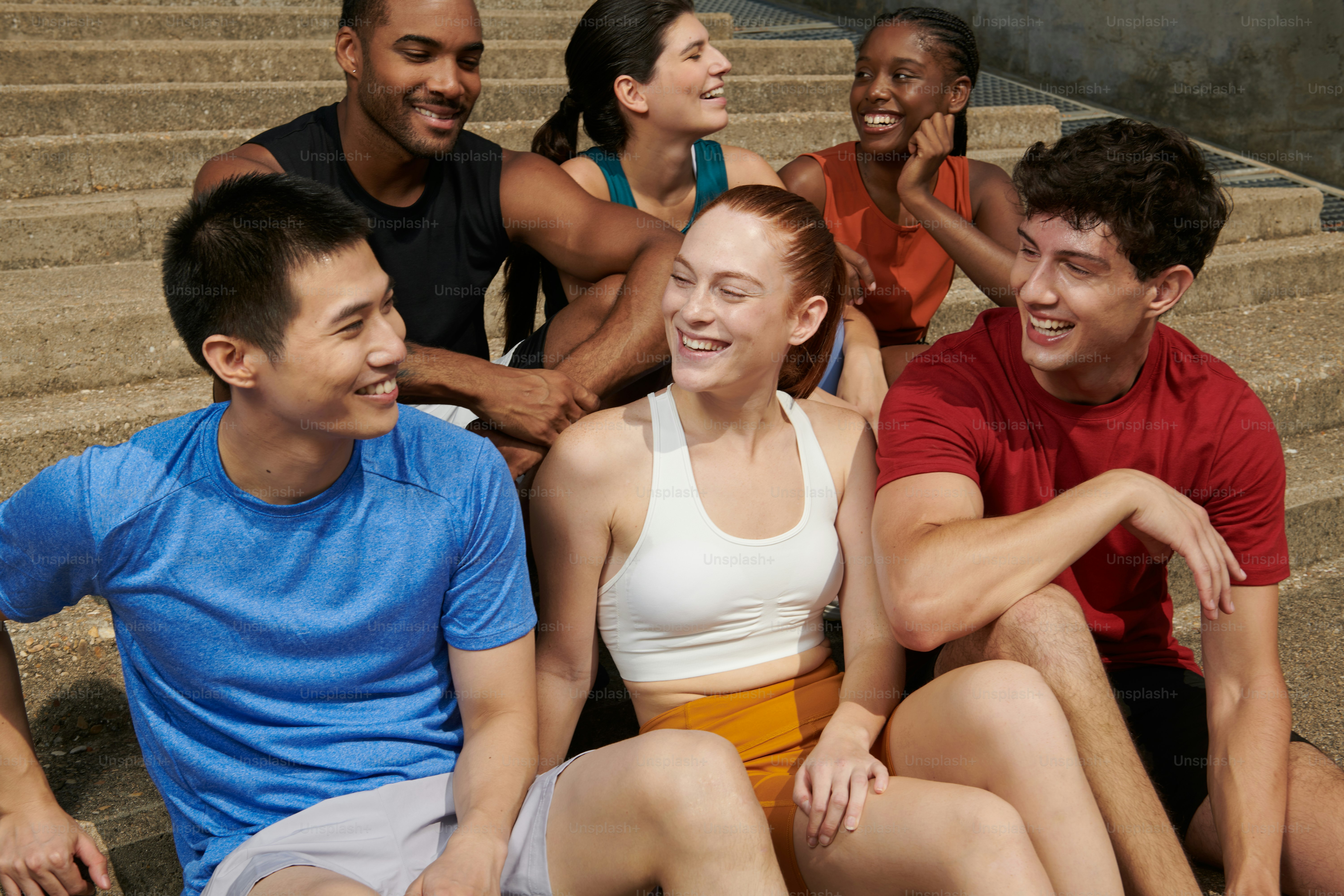Un gruppo di persone sedute sui gradini che ridono