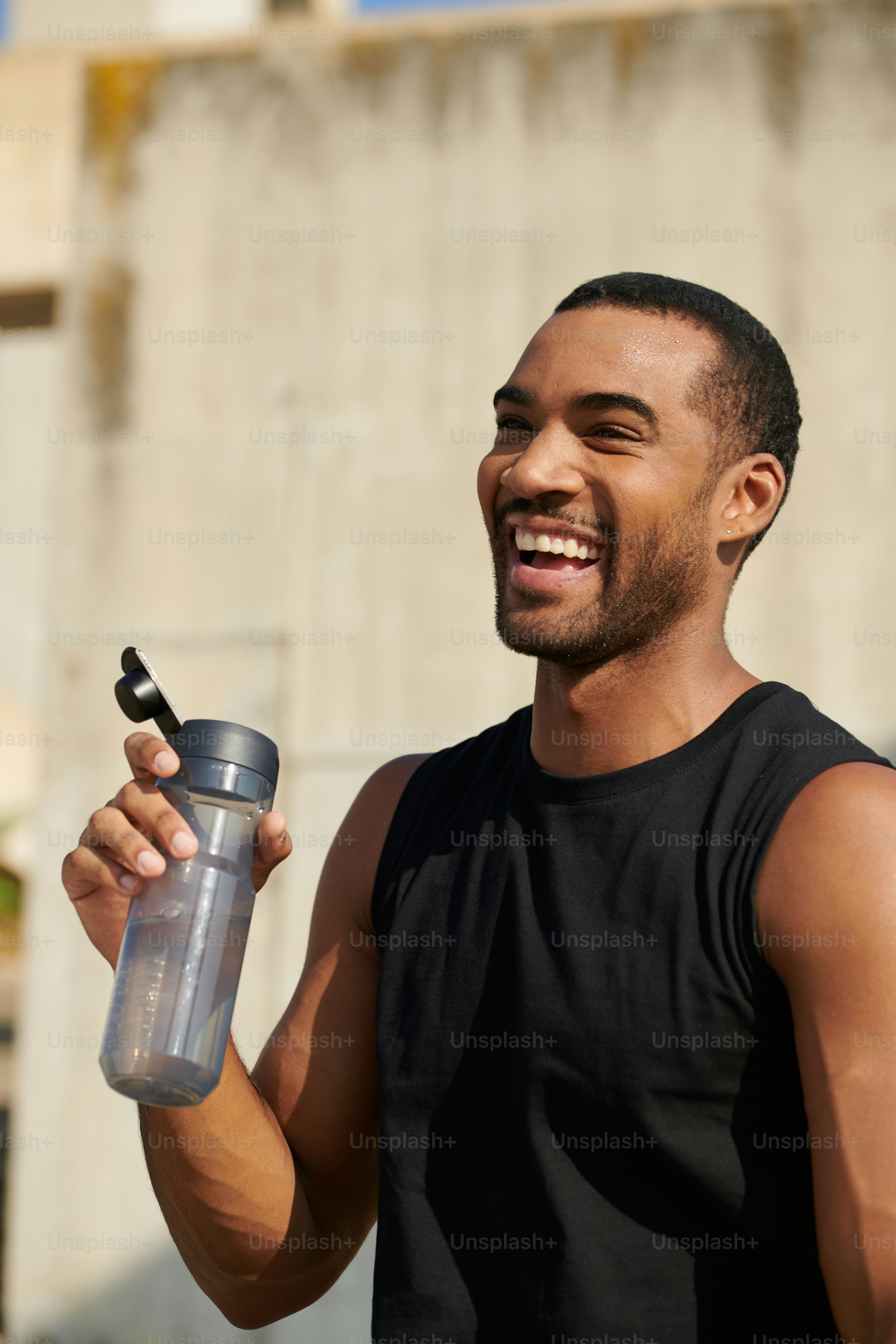 A man holding a water bottle and smiling