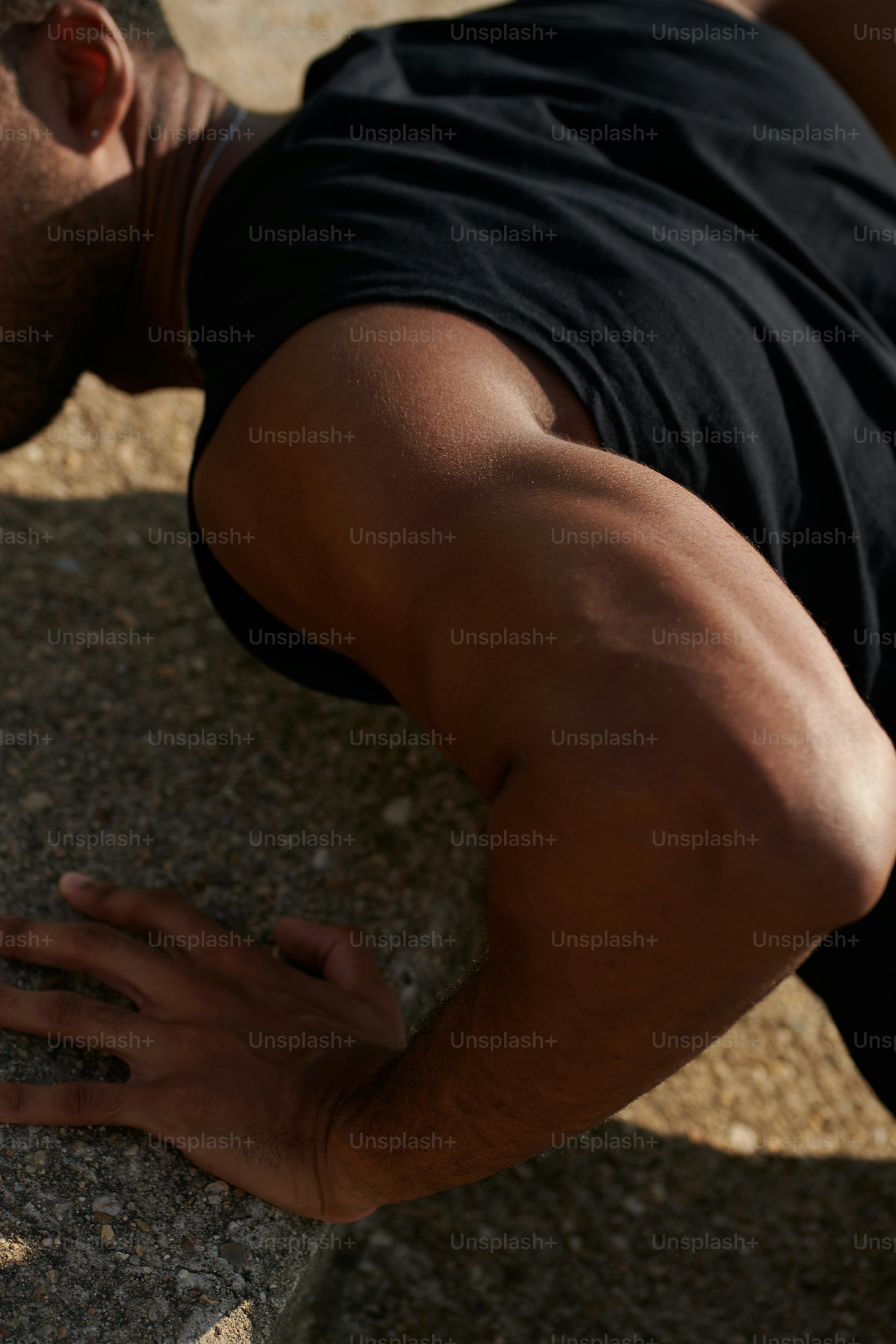 Un hombre apoyado en una roca con la mano en la cara