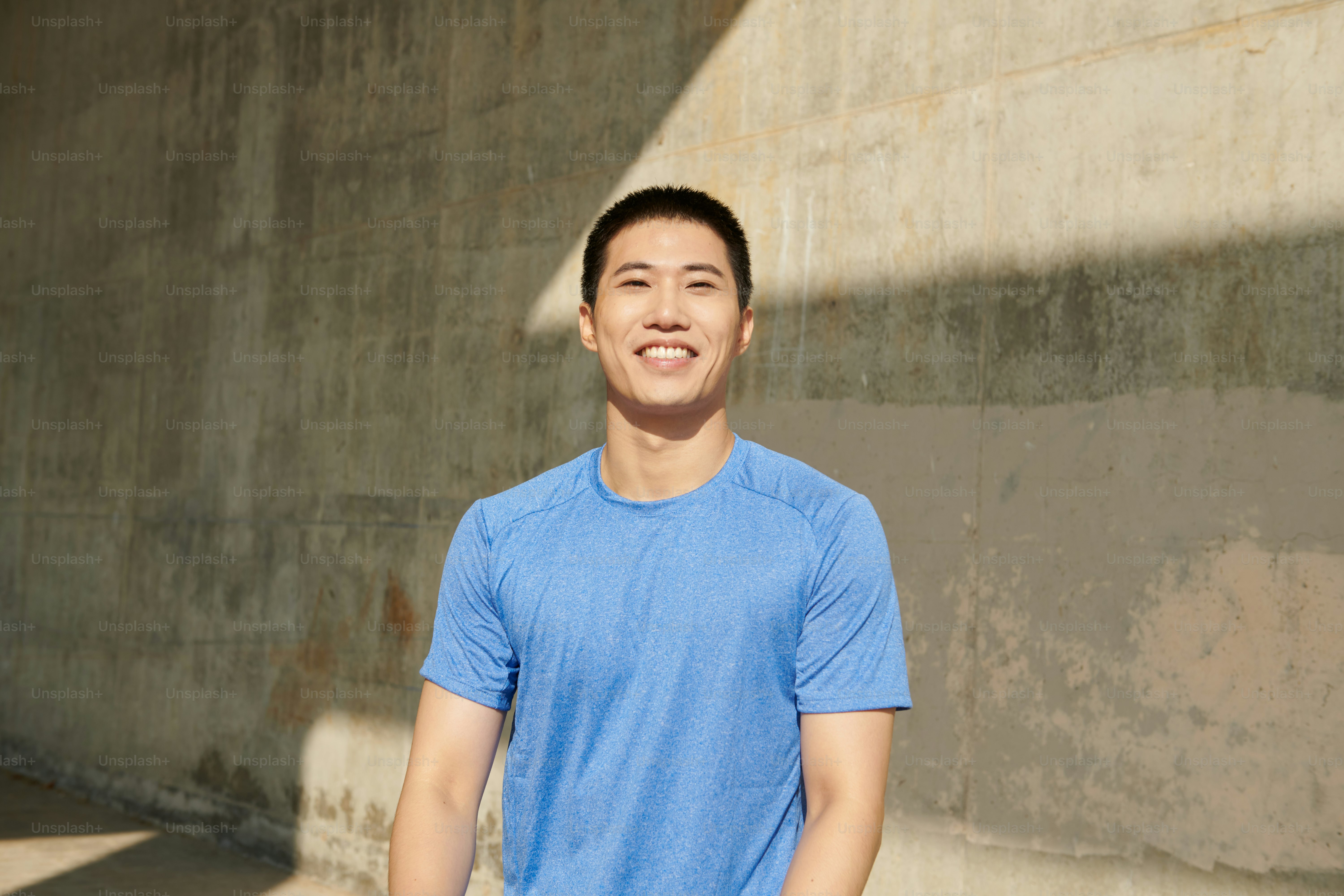 A man standing in front of a cement wall