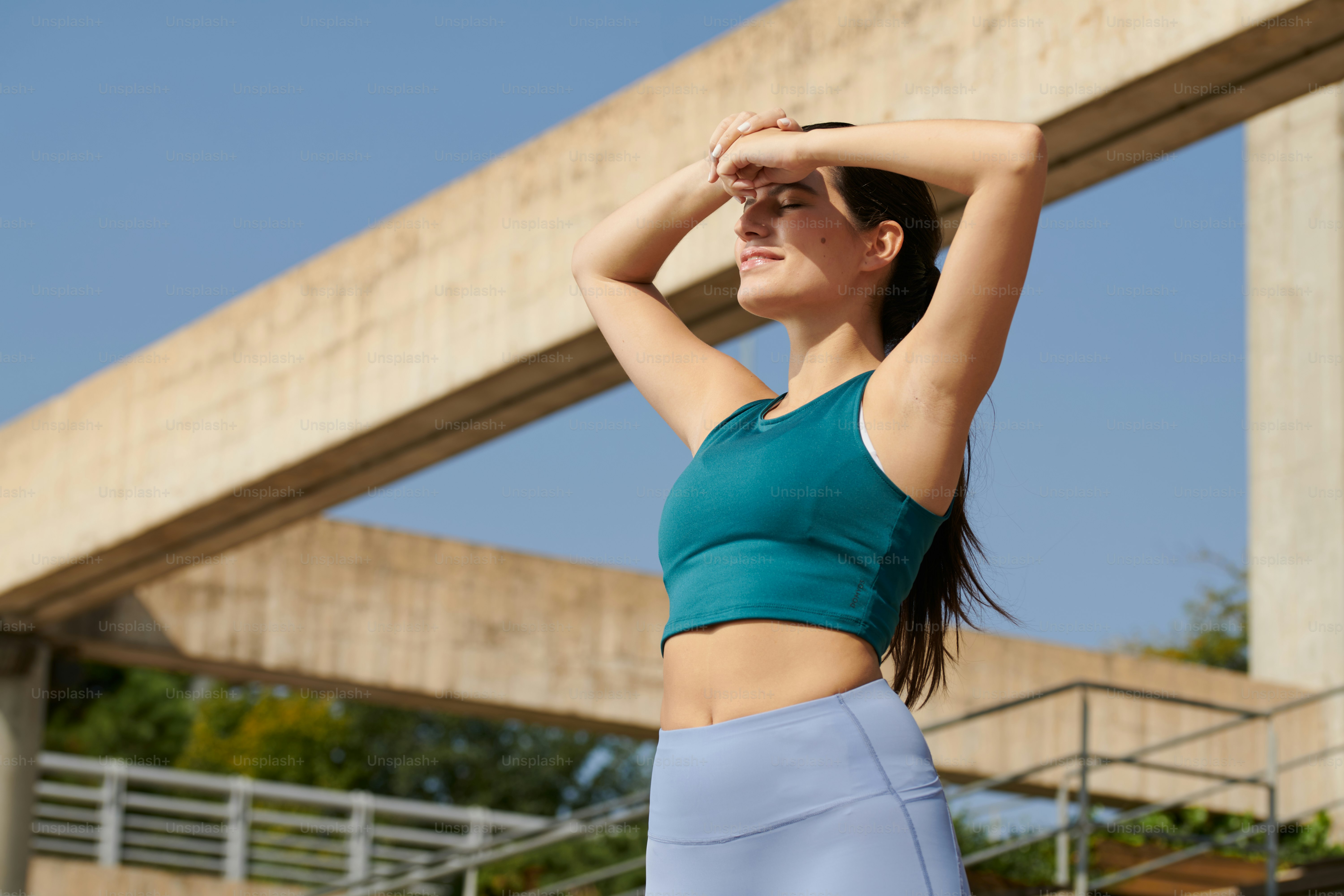 A woman in a sports bra top and leggings stands in front of a
