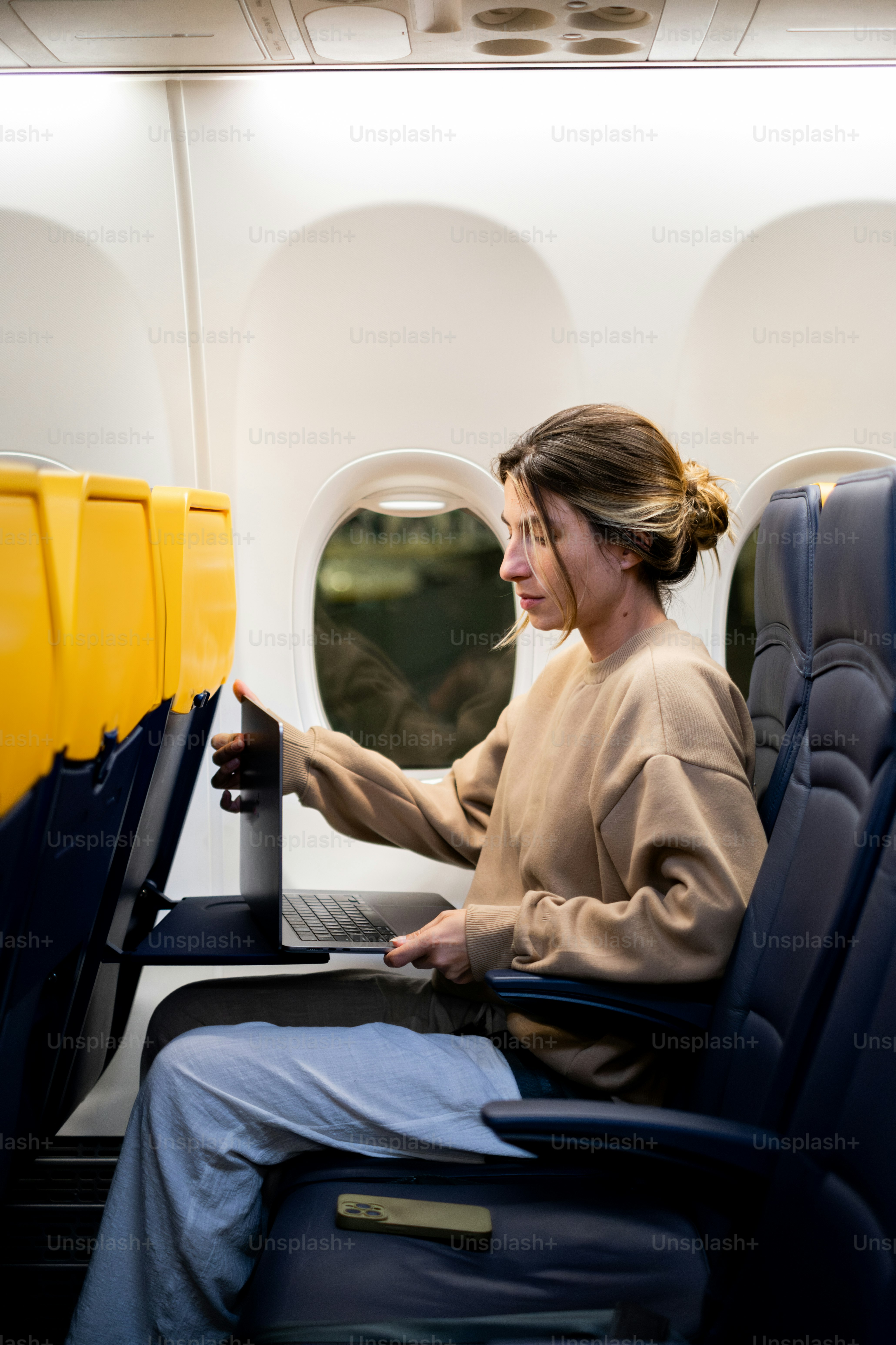 A woman sitting on a seat in an airplane