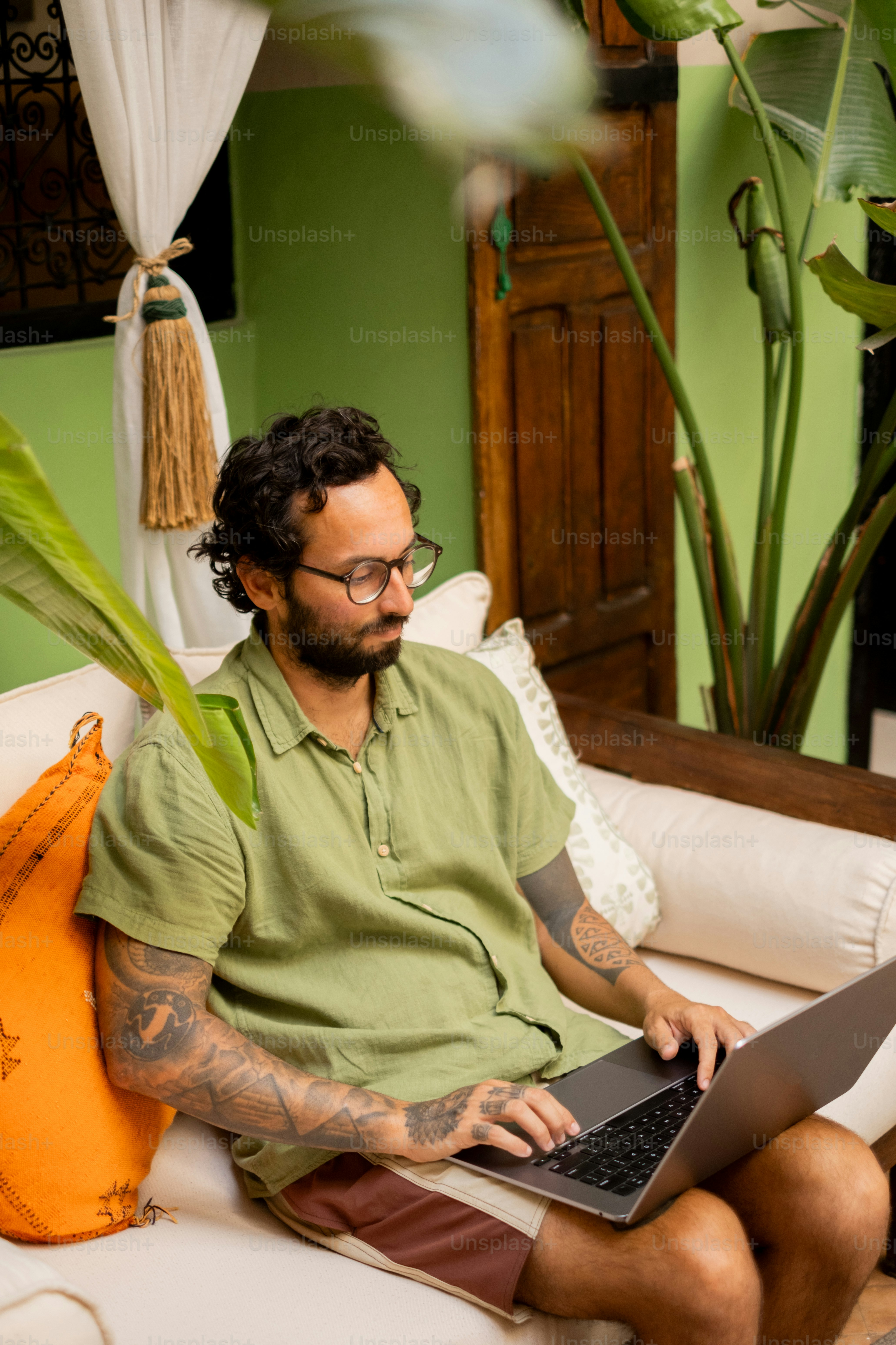A man sitting on a couch using a laptop computer