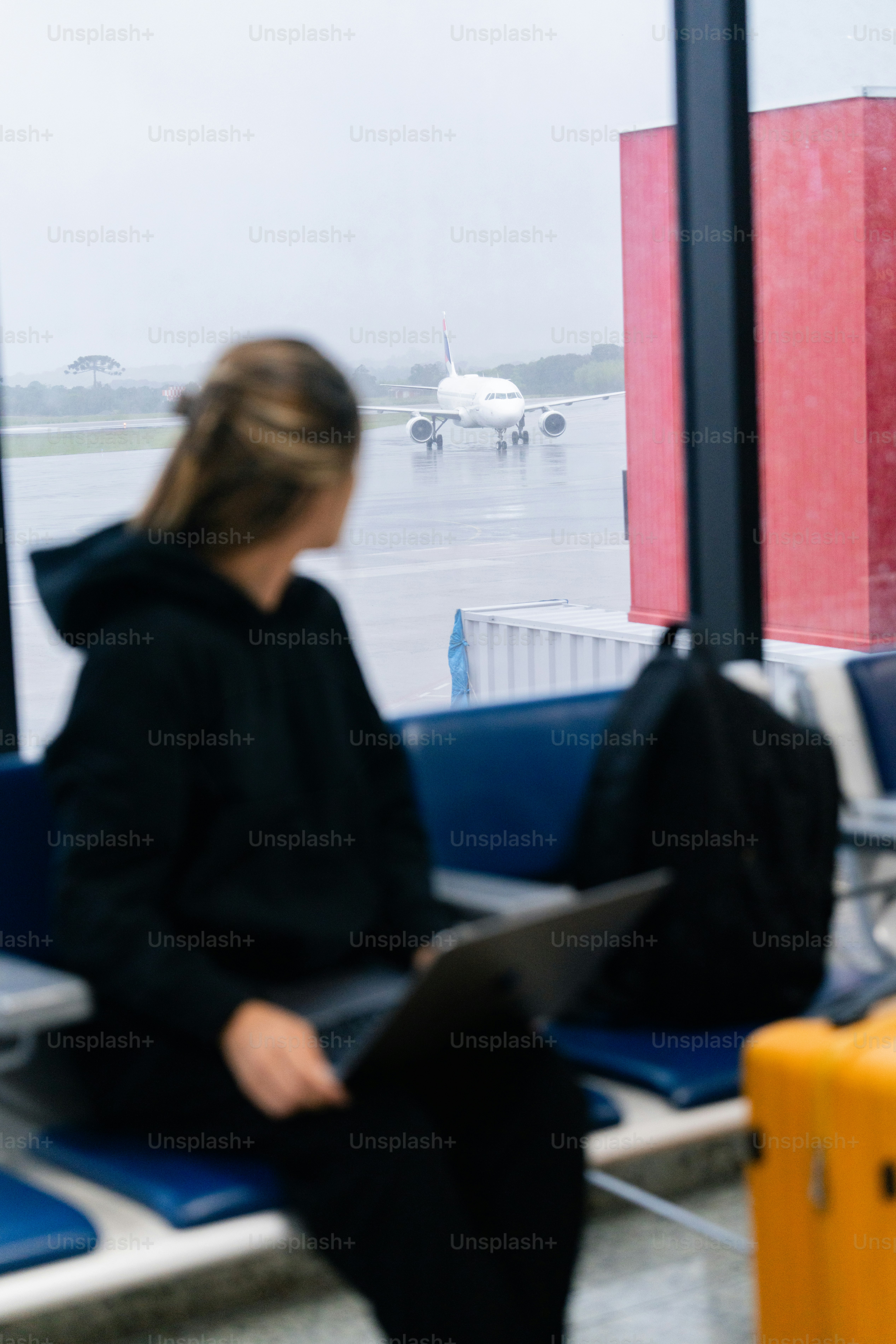 A woman sitting on a bench next to a window