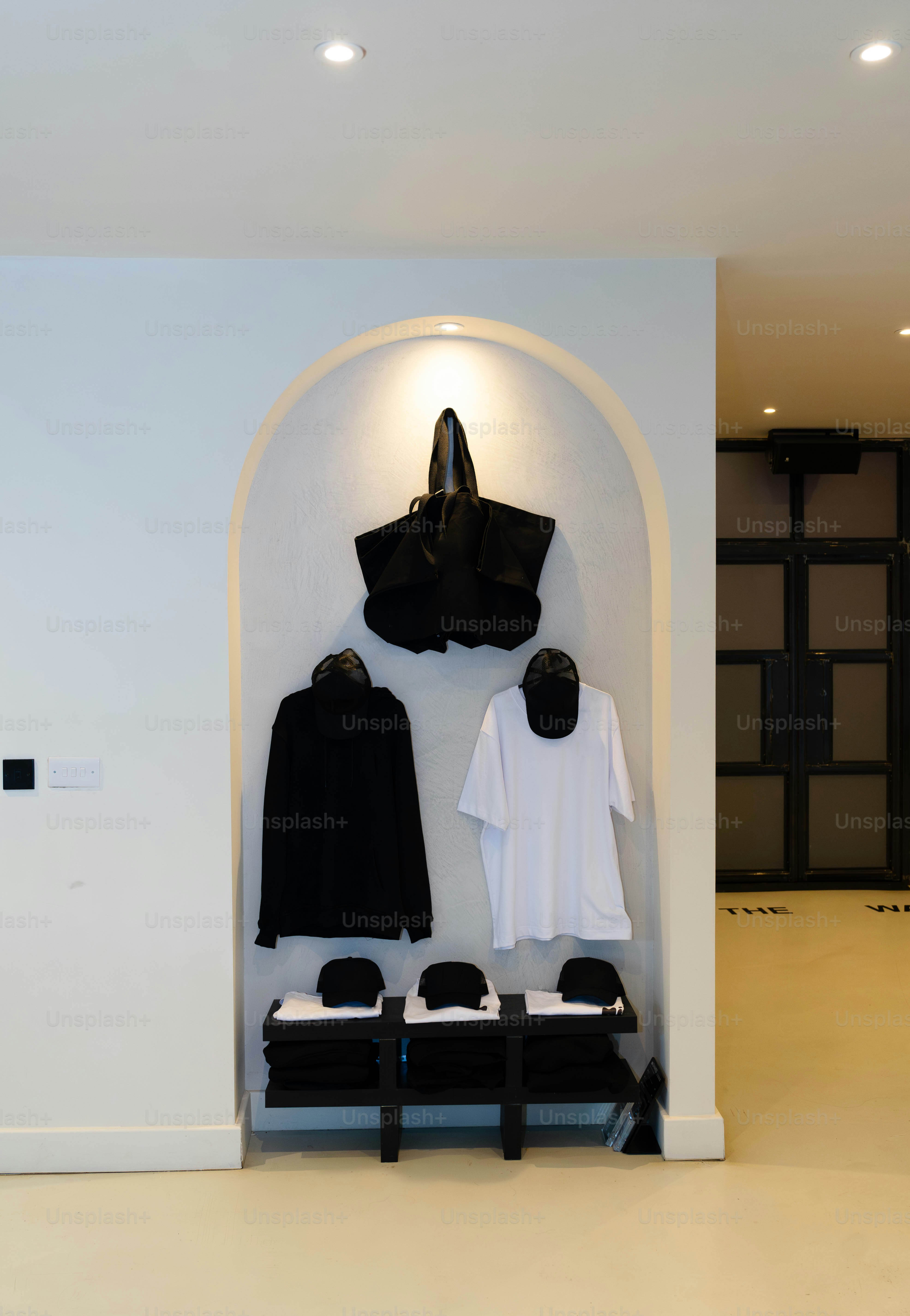 Uma sala branca com roupas pretas em exibição