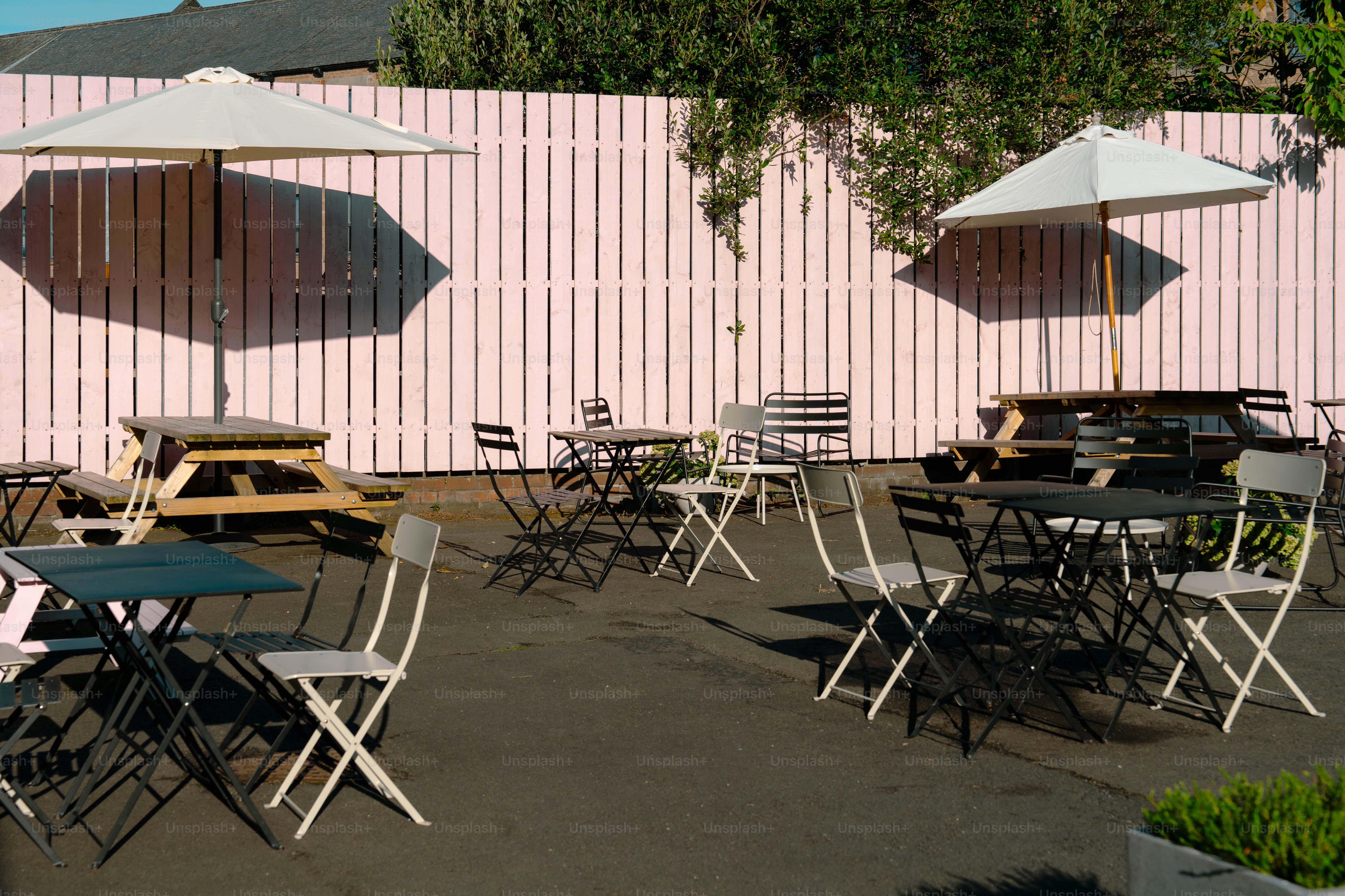 A group of tables and chairs with umbrellas