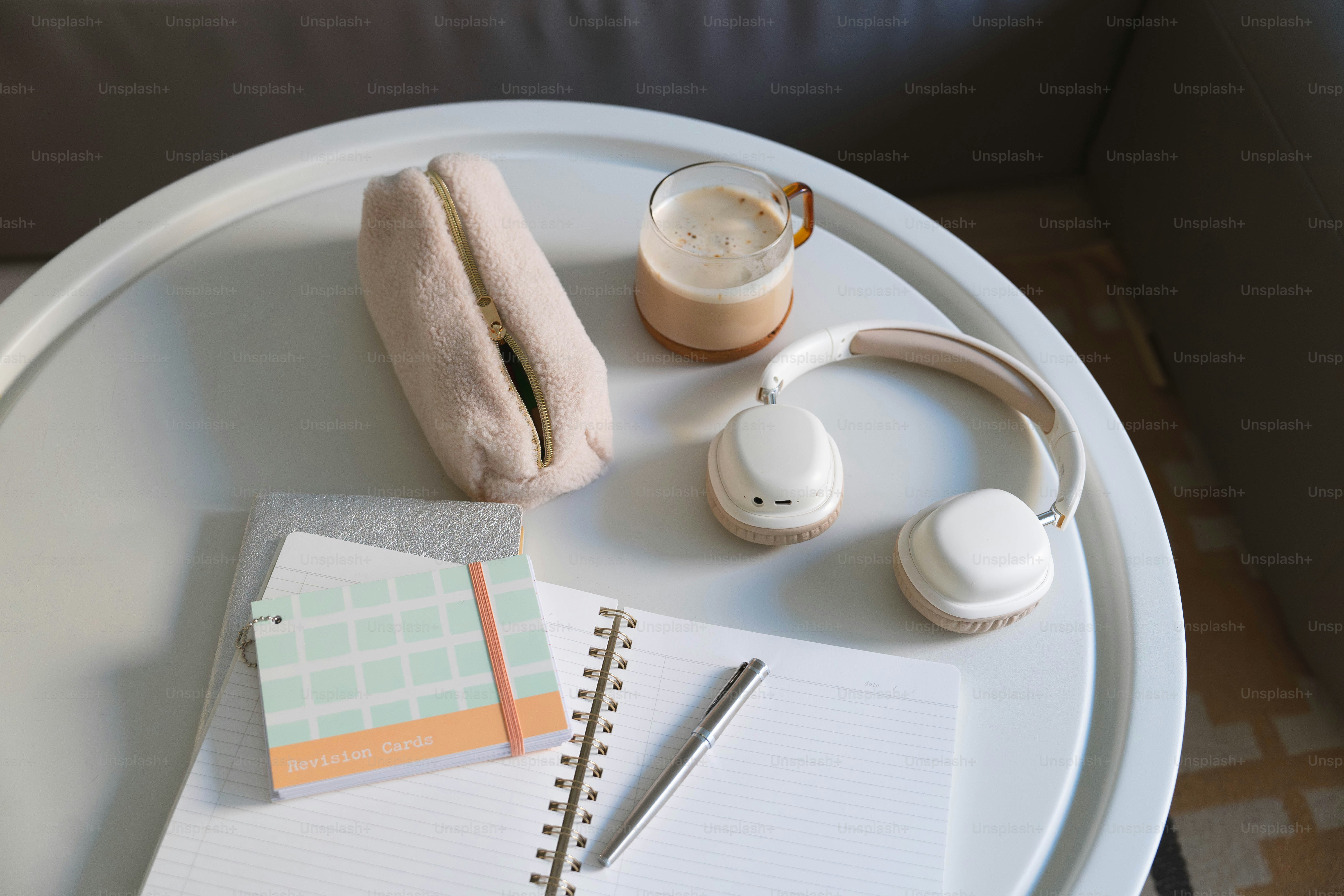 A white table topped with a laptop computer and headphones