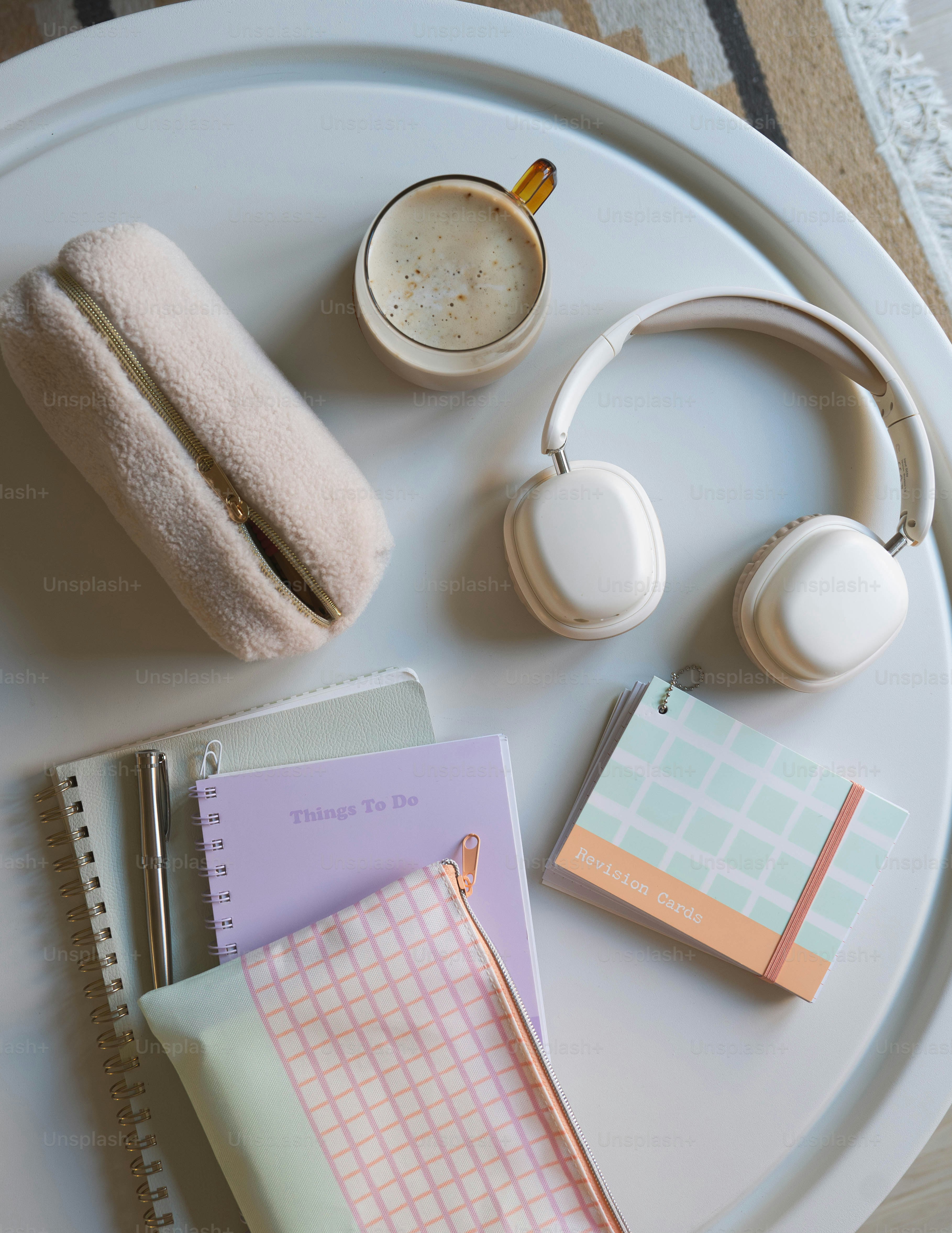 A white tray topped with headphones and notebooks